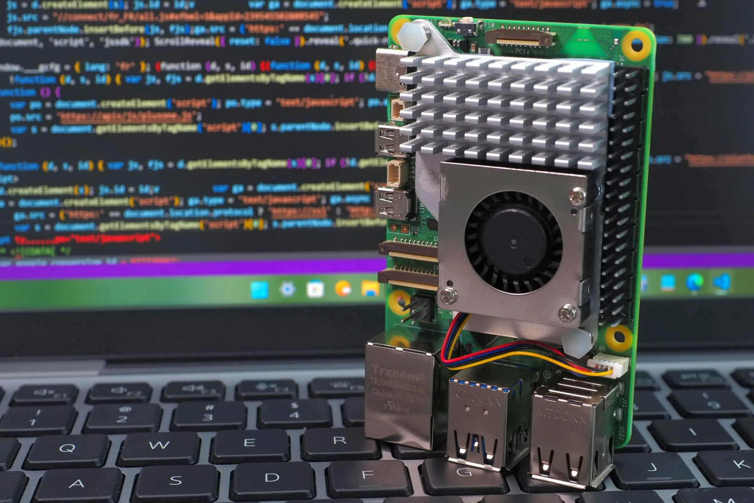 Ảnh cận cảnh máy tính Raspberry Pi 5 đặt trên bàn phím laptop, thường dùng để chạy Pi-hole chặn quảng cáo