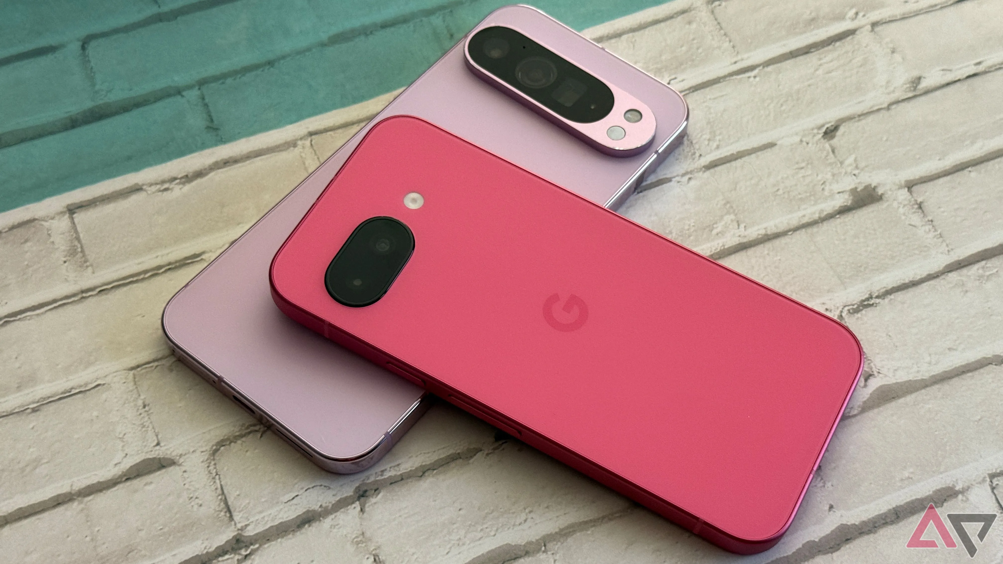 Điện thoại Google Pixel 9a đặt trên đỉnh của một chiếc Google Pixel 9 Pro XL, thể hiện thiết kế dòng Pixel