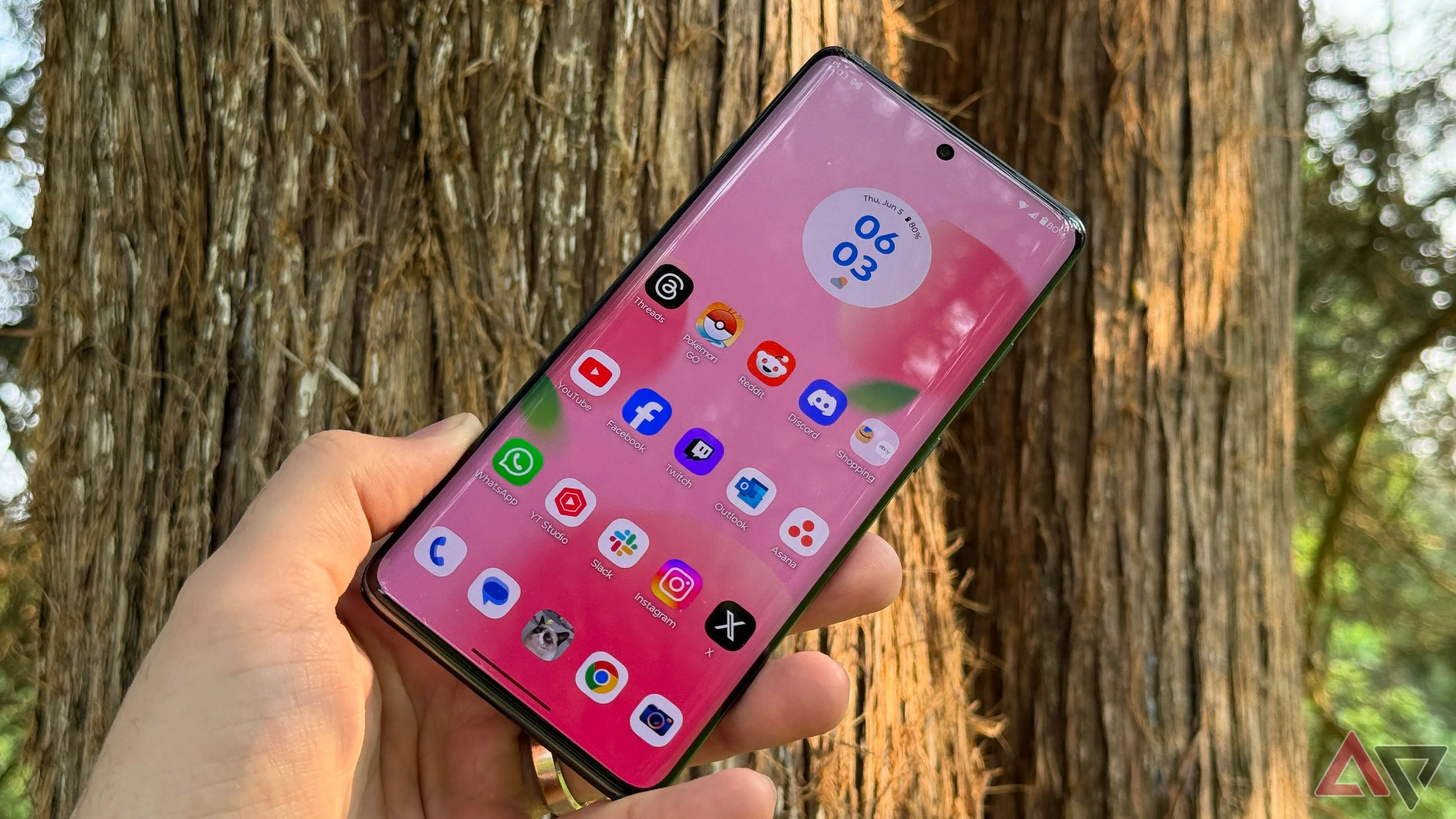Màn hình điện thoại Motorola Edge 2025 hiển thị ngoài trời, phía sau là thân cây.