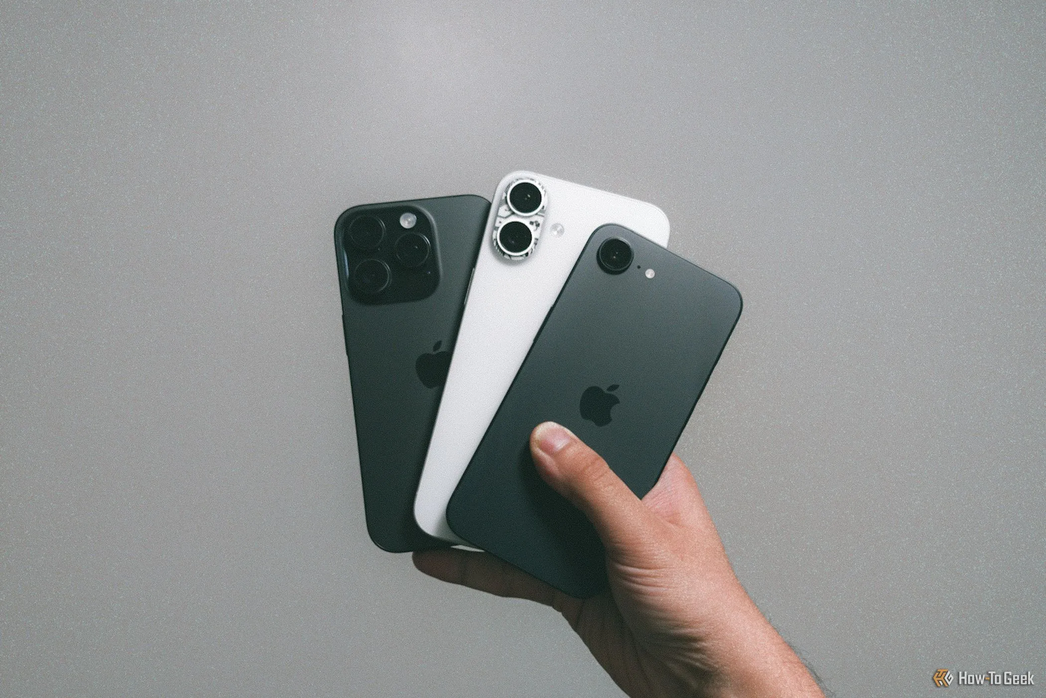 Một chiếc iPhone 16e cùng iPhone 16 Plus và iPhone 16 Pro được cầm trên tay, thể hiện thiết kế dự kiến của dòng iPhone tương lai