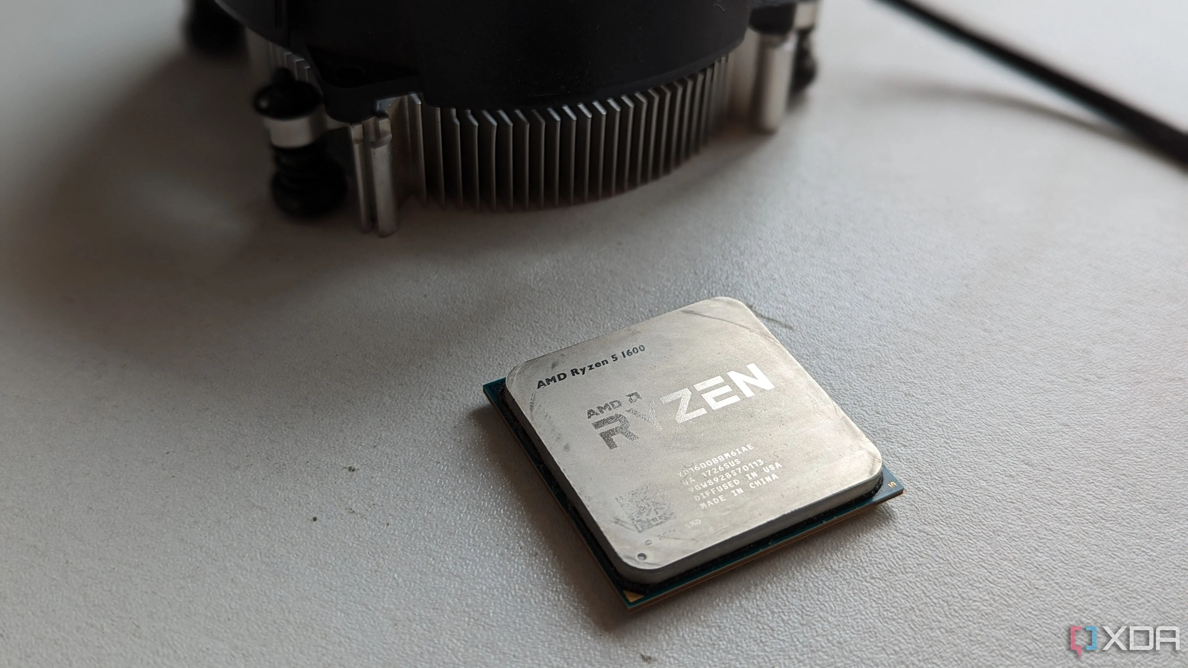 Bộ xử lý AMD Ryzen 5 1600 cùng tản nhiệt nguyên bản trên nền trắng.