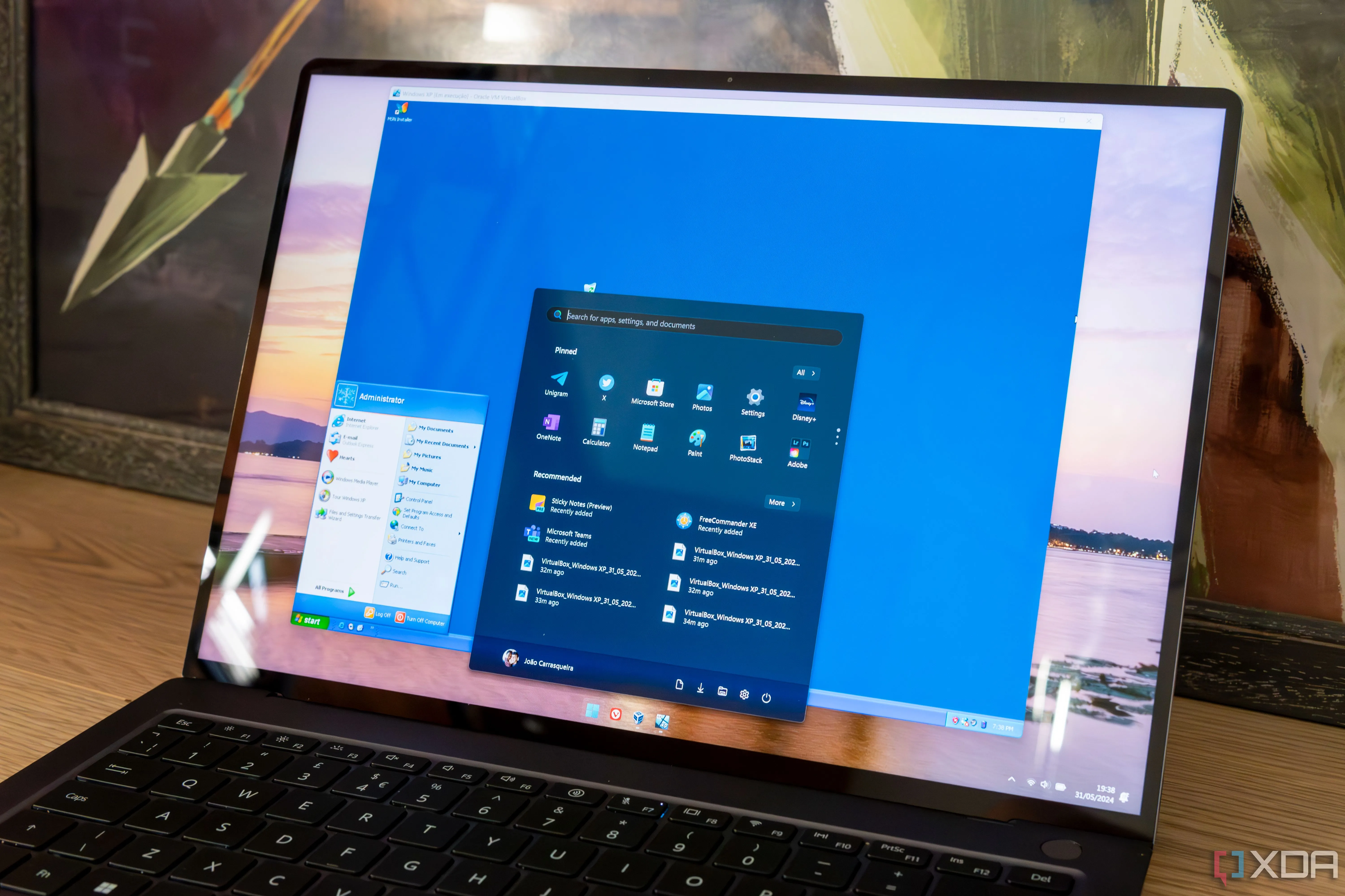 Laptop chạy Windows 11 hiển thị máy ảo Windows XP, minh họa khả năng tương thích ngược của VM.