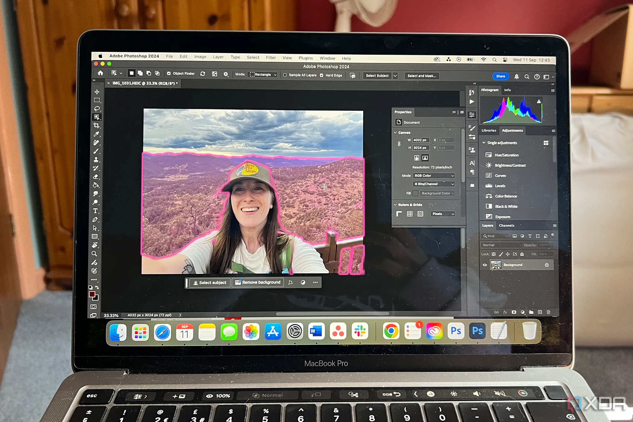 Màn hình MacBook hiển thị Adobe Photoshop với công cụ chọn đối tượng AI trên ảnh chân dung nữ, minh họa khả năng tích hợp trí tuệ nhân tạo trong phần mềm độc quyền.