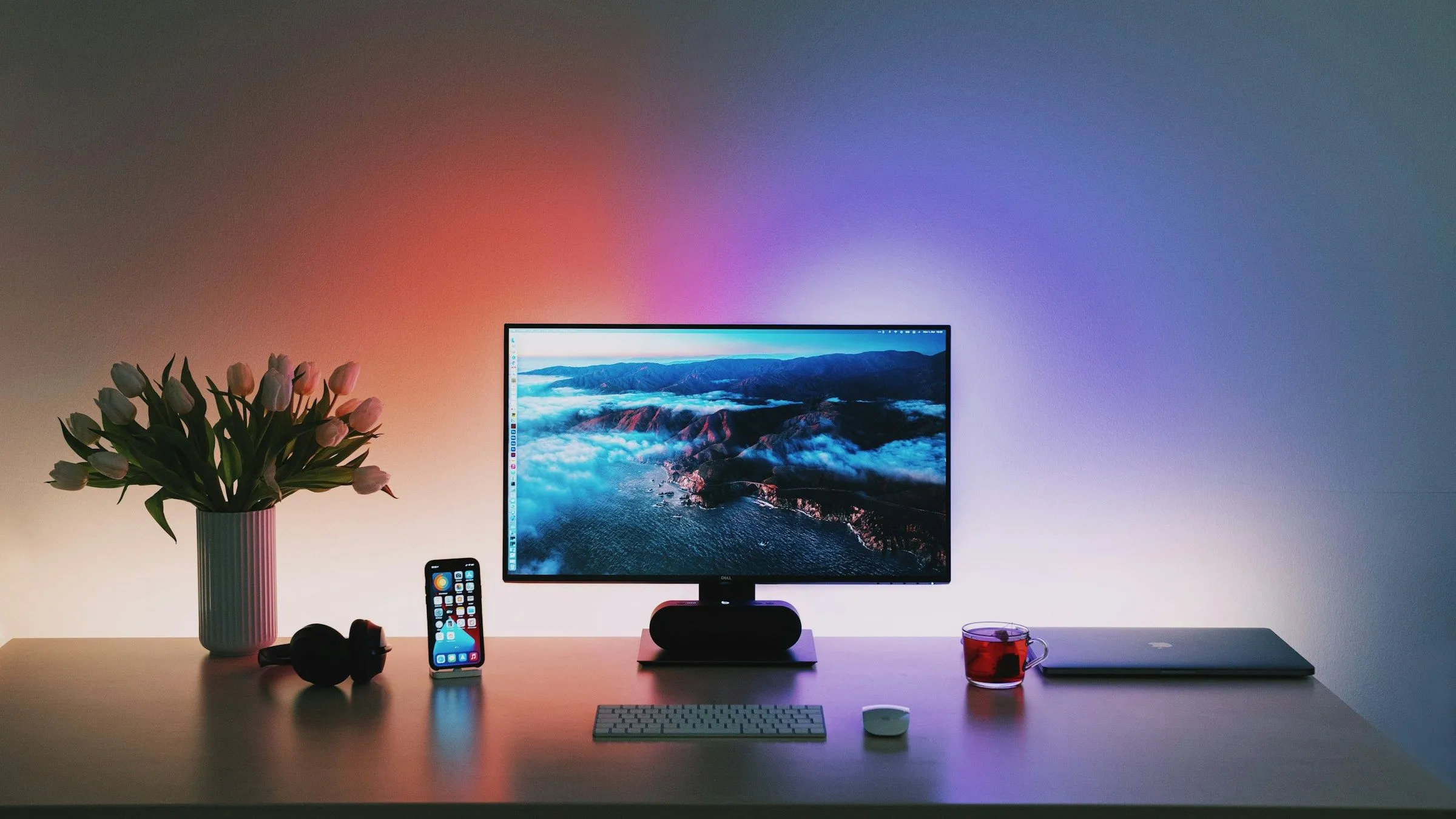 Bàn làm việc với bộ máy tính PC được quản lý cáp gọn gàng và đèn nền khuếch tán phía sau màn hình