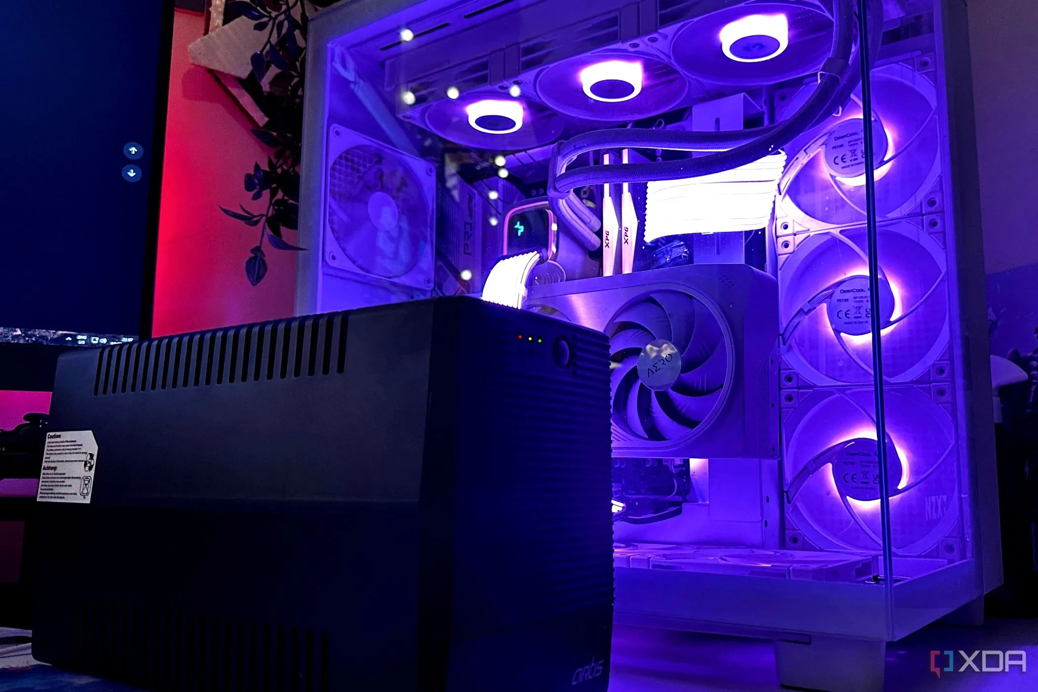 Bộ lưu điện UPS màu đen đặt cạnh thùng máy tính gaming, biểu tượng của sự bảo vệ hệ thống khỏi sự cố điện.