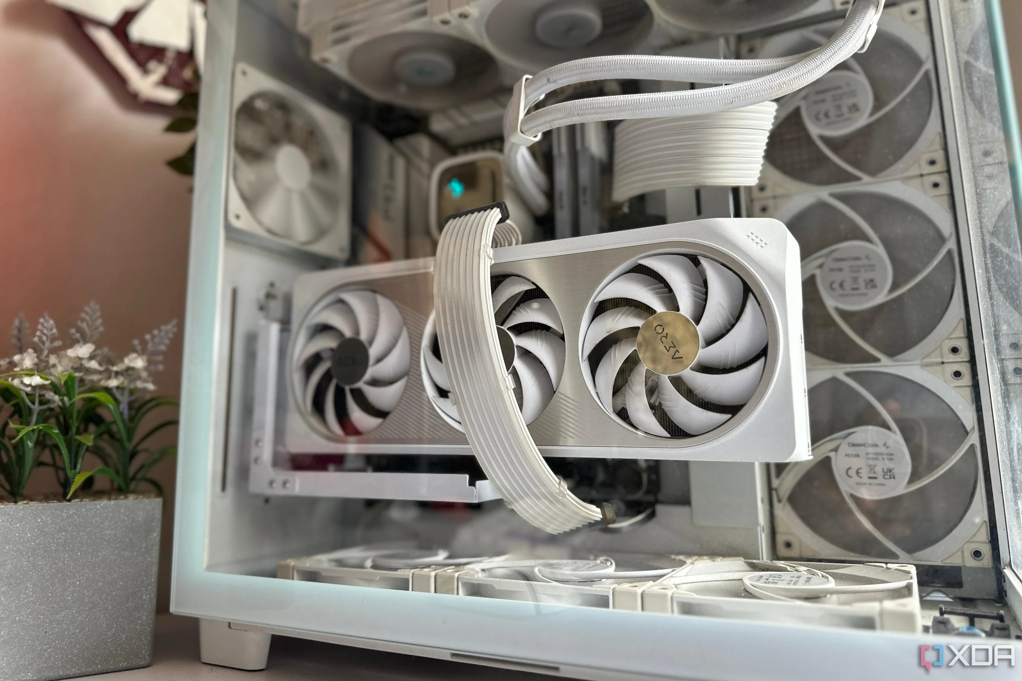 Bộ PC gaming tông màu trắng với card đồ họa trắng nổi bật trên bàn, thể hiện xu hướng cá nhân hóa và thẩm mỹ cao.