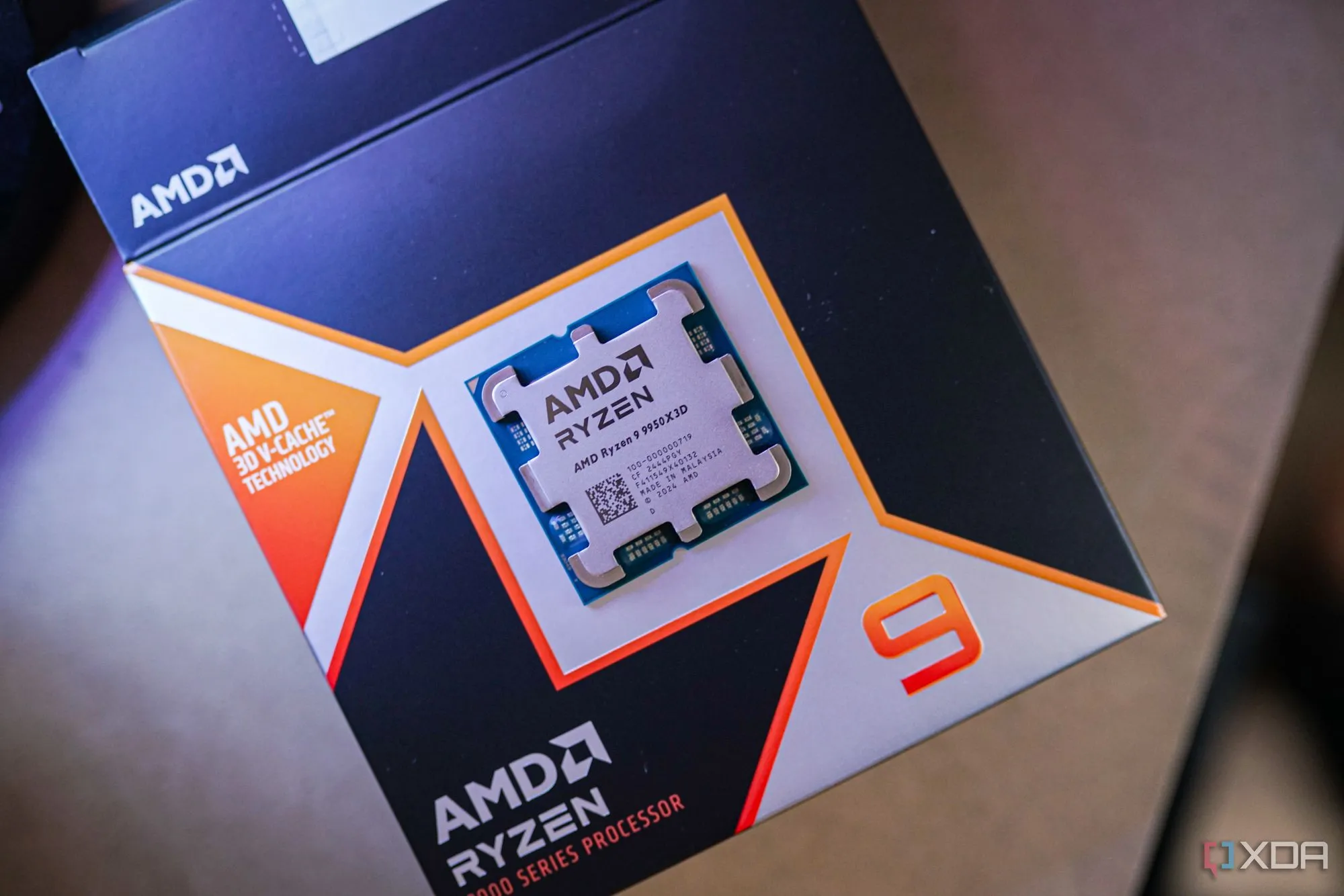 Bộ vi xử lý AMD Ryzen 9 9950X3D màu đen đặt trên vỏ hộp, làm nổi bật thiết kế và thương hiệu.