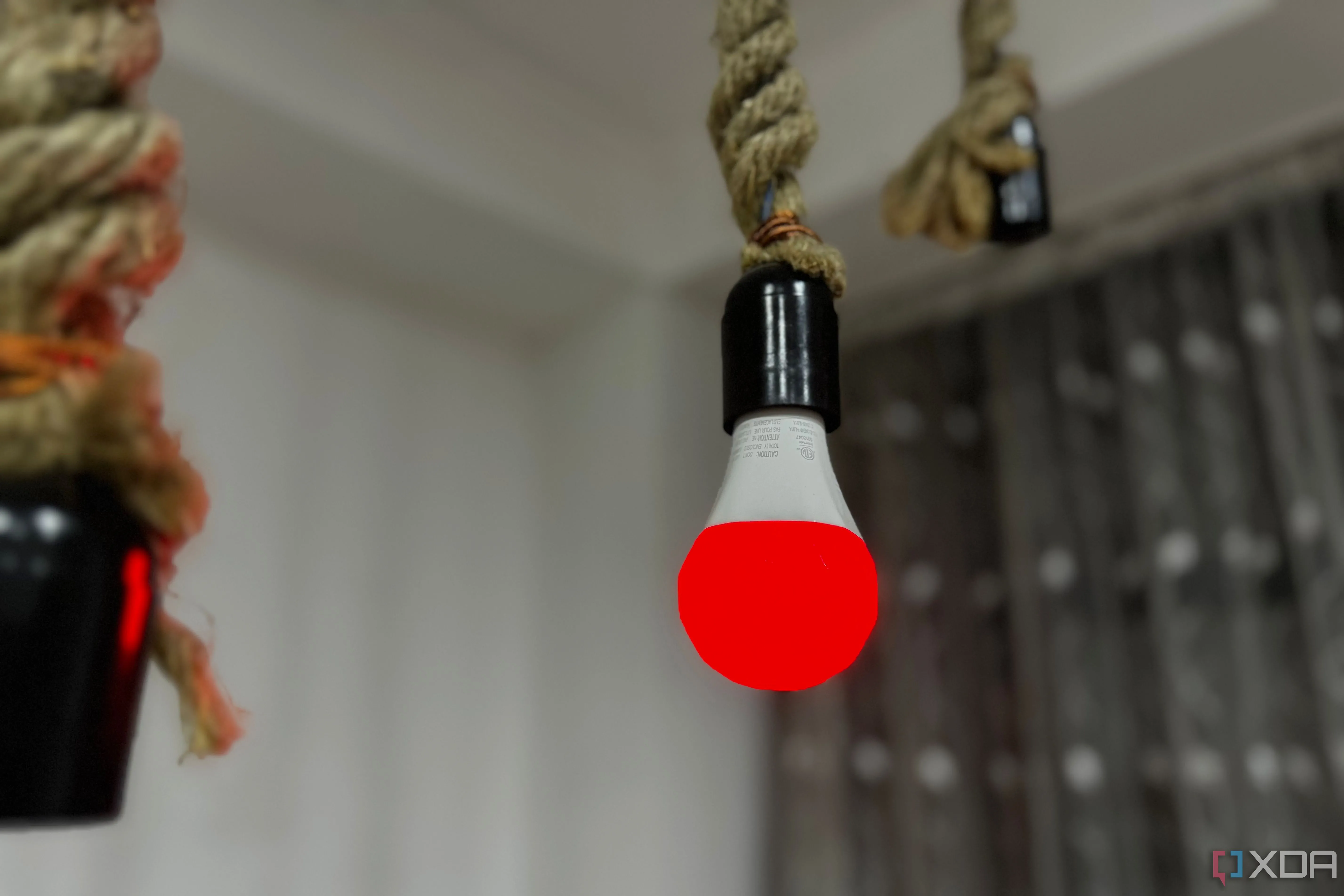 Bóng đèn thông minh Nanoleaf Essentials A19 | E26 được chiếu sáng màu đỏ, đại diện cho thiết bị IoT tiềm ẩn rủi ro bảo mật