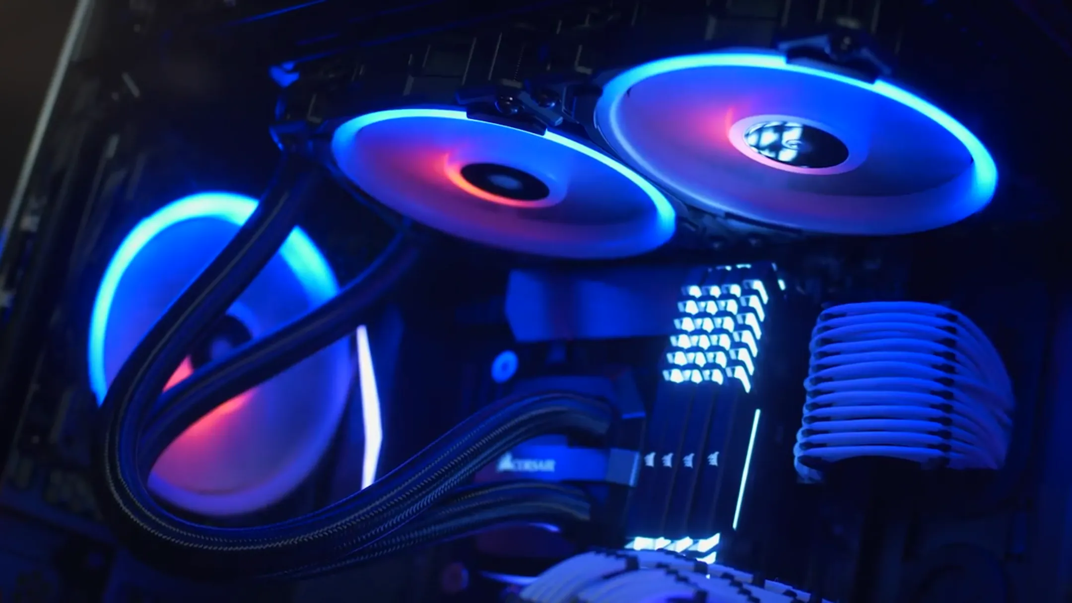 Các quạt tản nhiệt Corsair LL120 RGB đang hoạt động bên trong vỏ case PC, tạo hiệu ứng ánh sáng đẹp mắt và luồng khí mạnh mẽ.