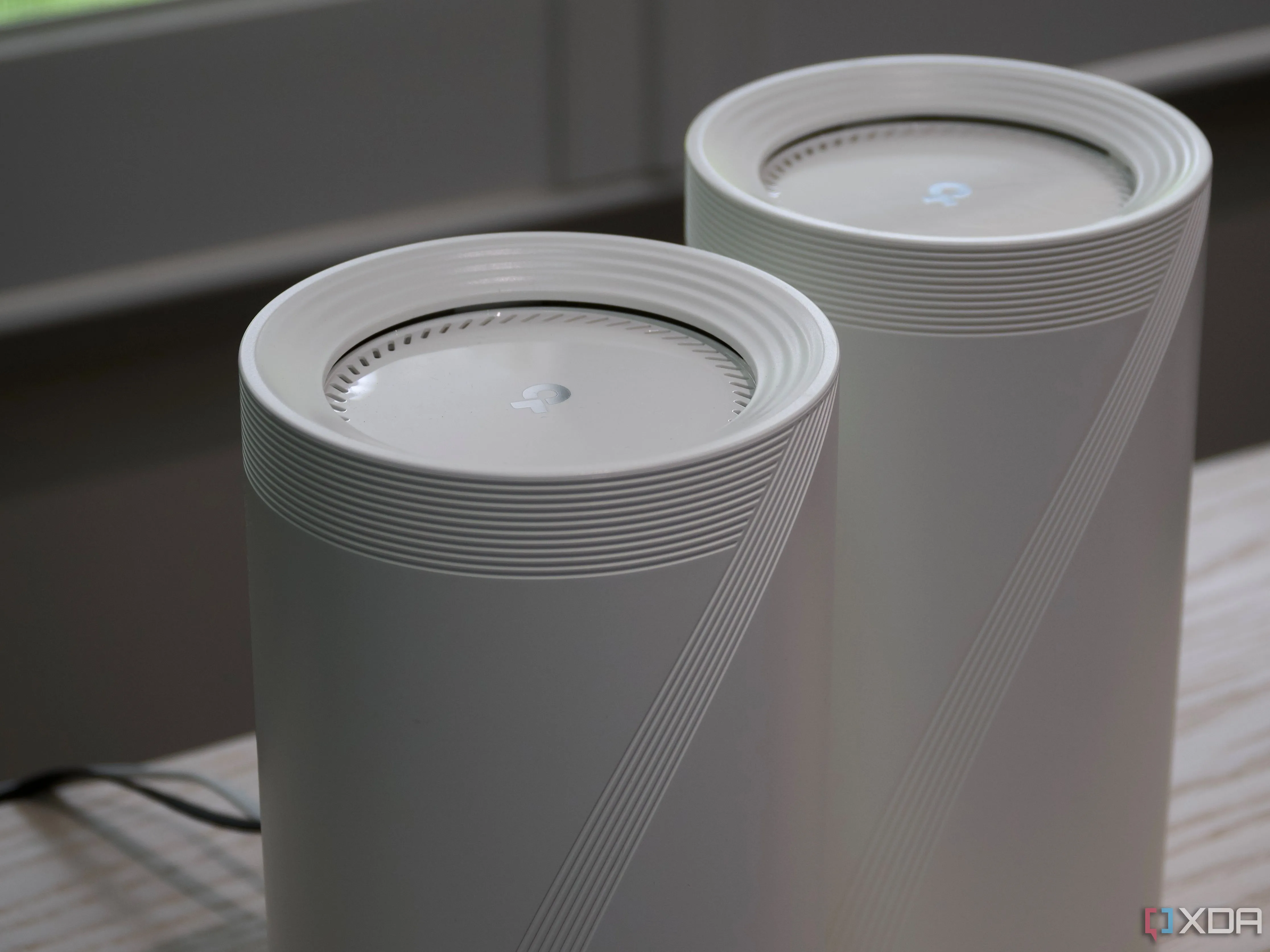 Hình ảnh cận cảnh hệ thống Mesh TP-Link Deco BE85 với thiết kế tản nhiệt ở mặt trên, nhấn mạnh vào chất lượng phần cứng cao cấp.
