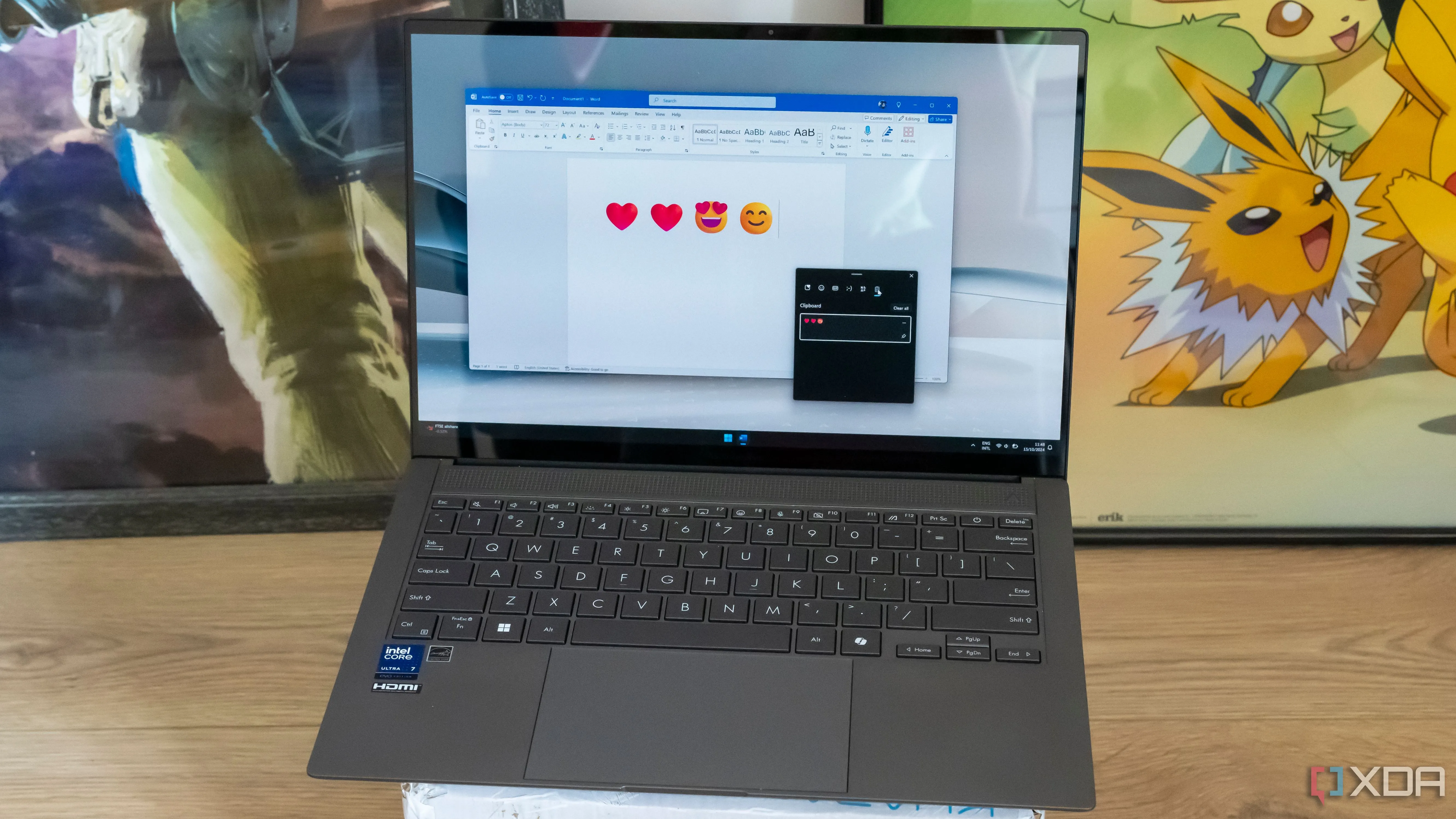 Laptop hiển thị Microsoft Word với các biểu tượng cảm xúc và bảng điều khiển Clipboard, thể hiện khả năng chỉnh sửa đa dạng