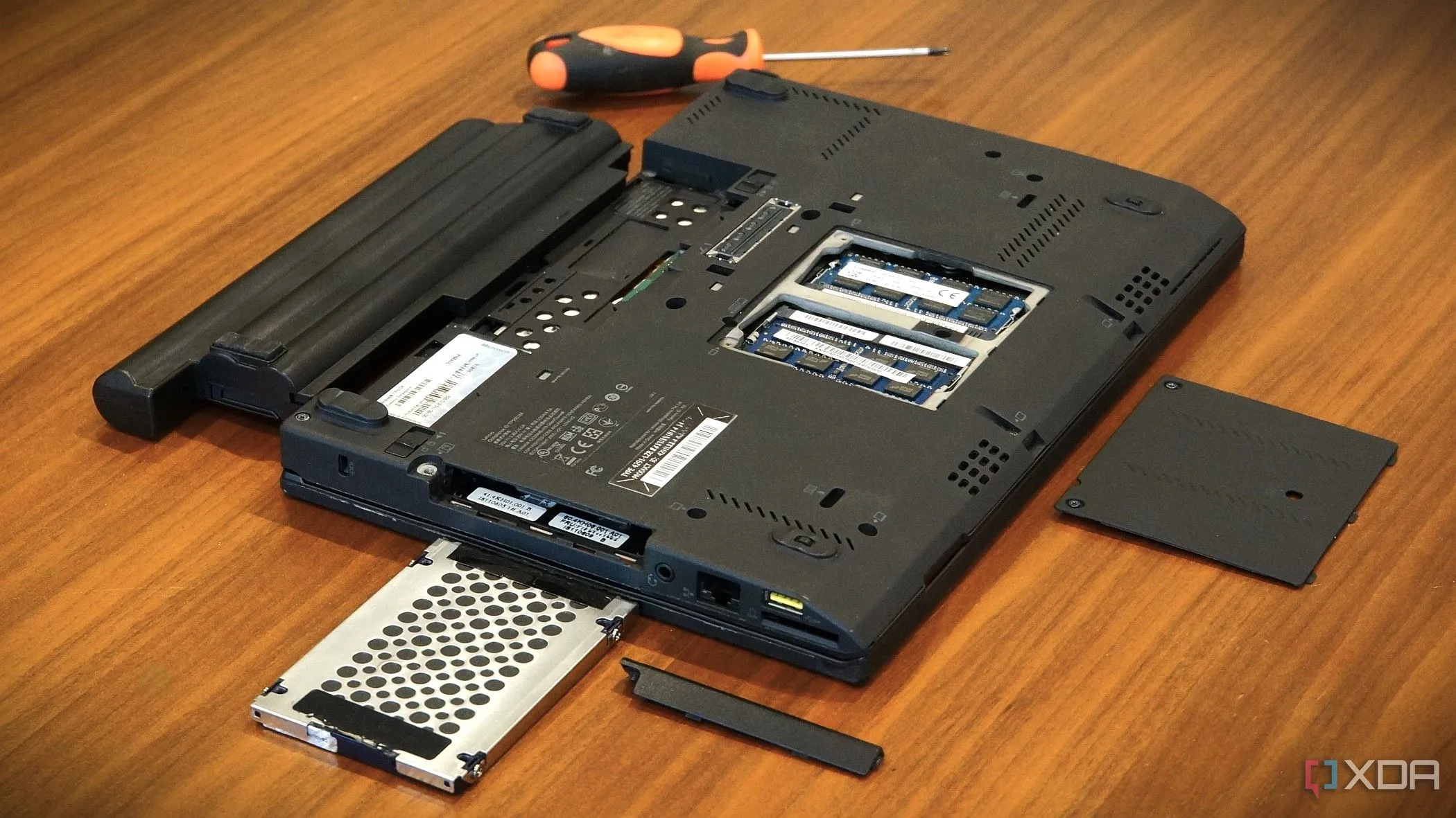 Laptop Lenovo X220 với khoang pin mở, thể hiện việc tháo lắp pin để nâng cấp