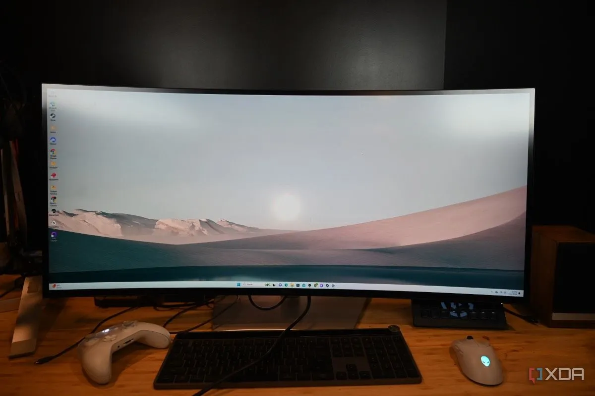Màn hình cong Dell UltraSharp 40 Thunderbolt lớn hiển thị hình nền sa mạc, thành phần quan trọng trong góc làm việc