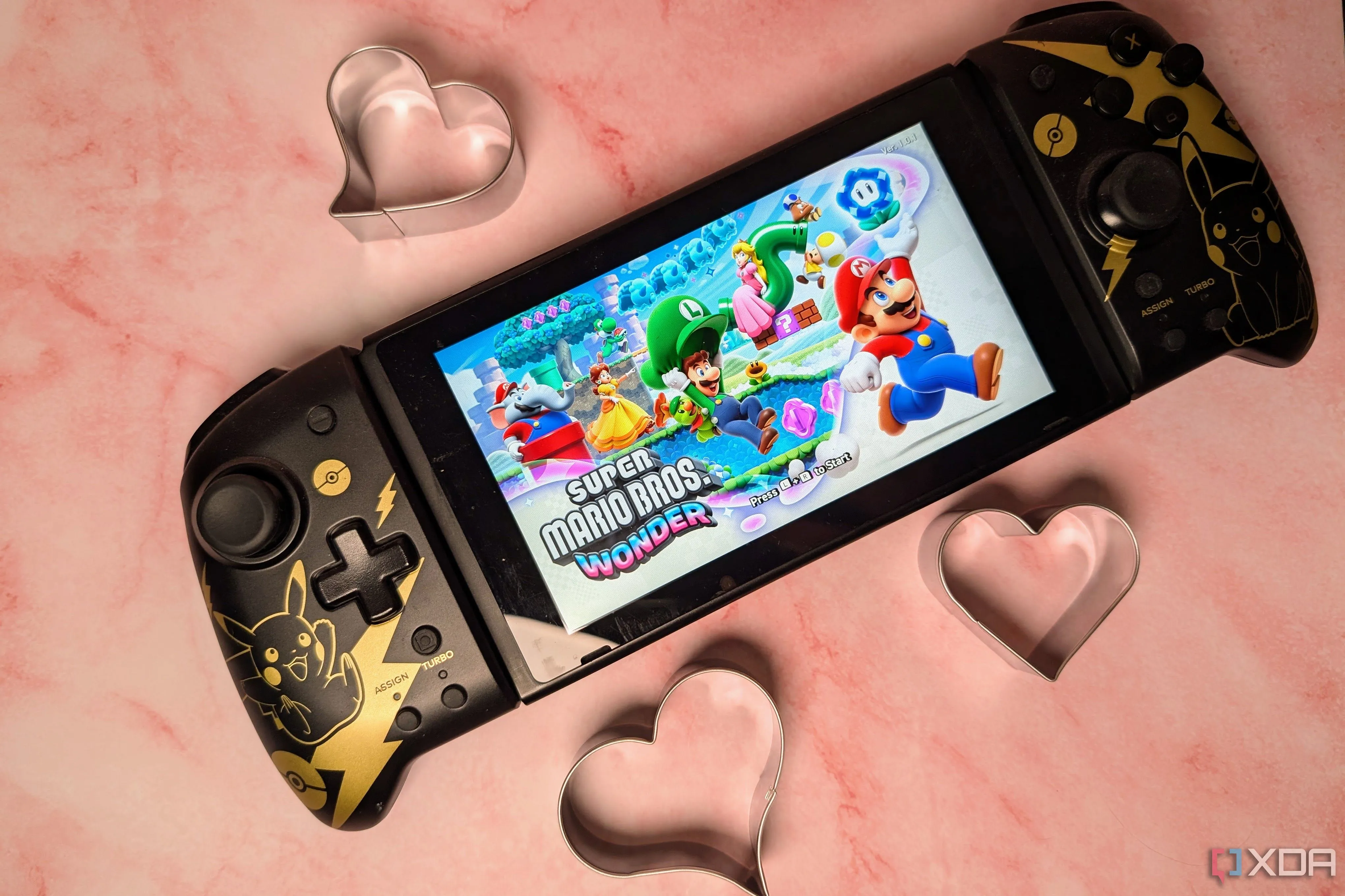 Máy chơi game Nintendo Switch với tựa game Mario Wonder hiển thị trên màn hình, bao quanh bởi các biểu tượng trái tim, biểu tượng cho game co-op lãng mạn