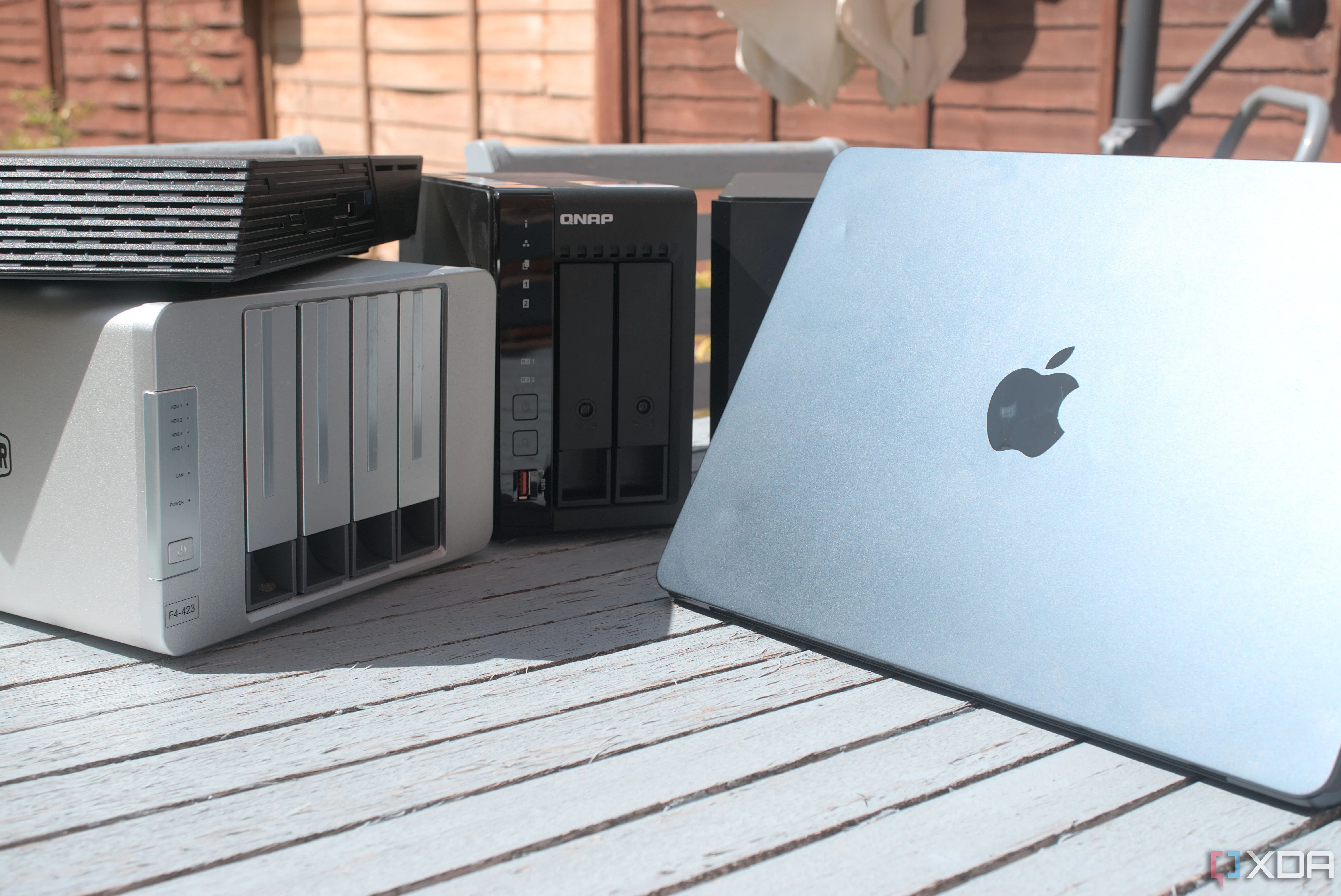 Máy tính MacBook Air kết nối với thiết bị NAS, tượng trưng cho việc sử dụng NAS để tự host các dịch vụ như Minecraft server tại nhà