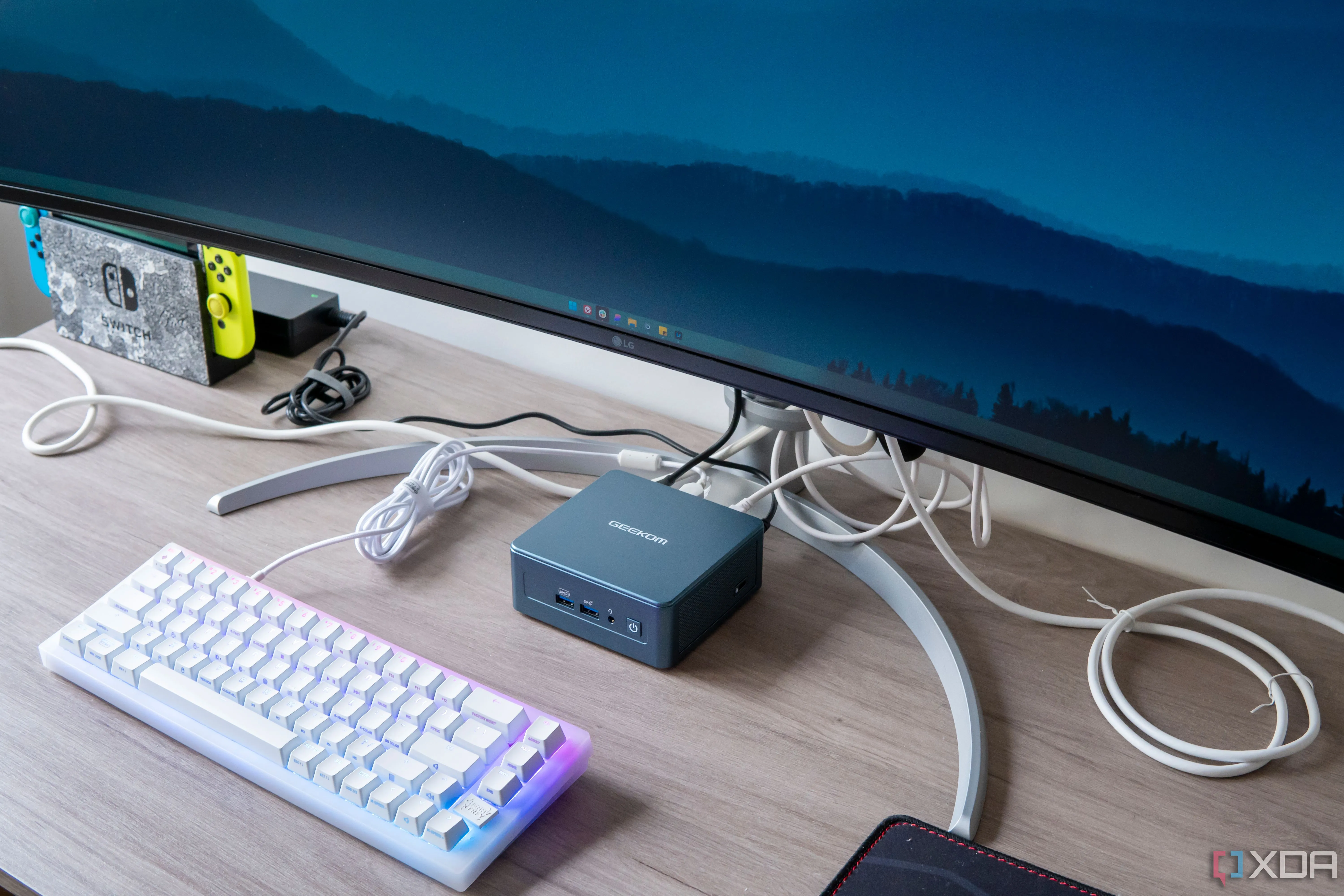 Máy tính mini Geekom Mini IT13 đặt dưới màn hình, cùng bàn phím