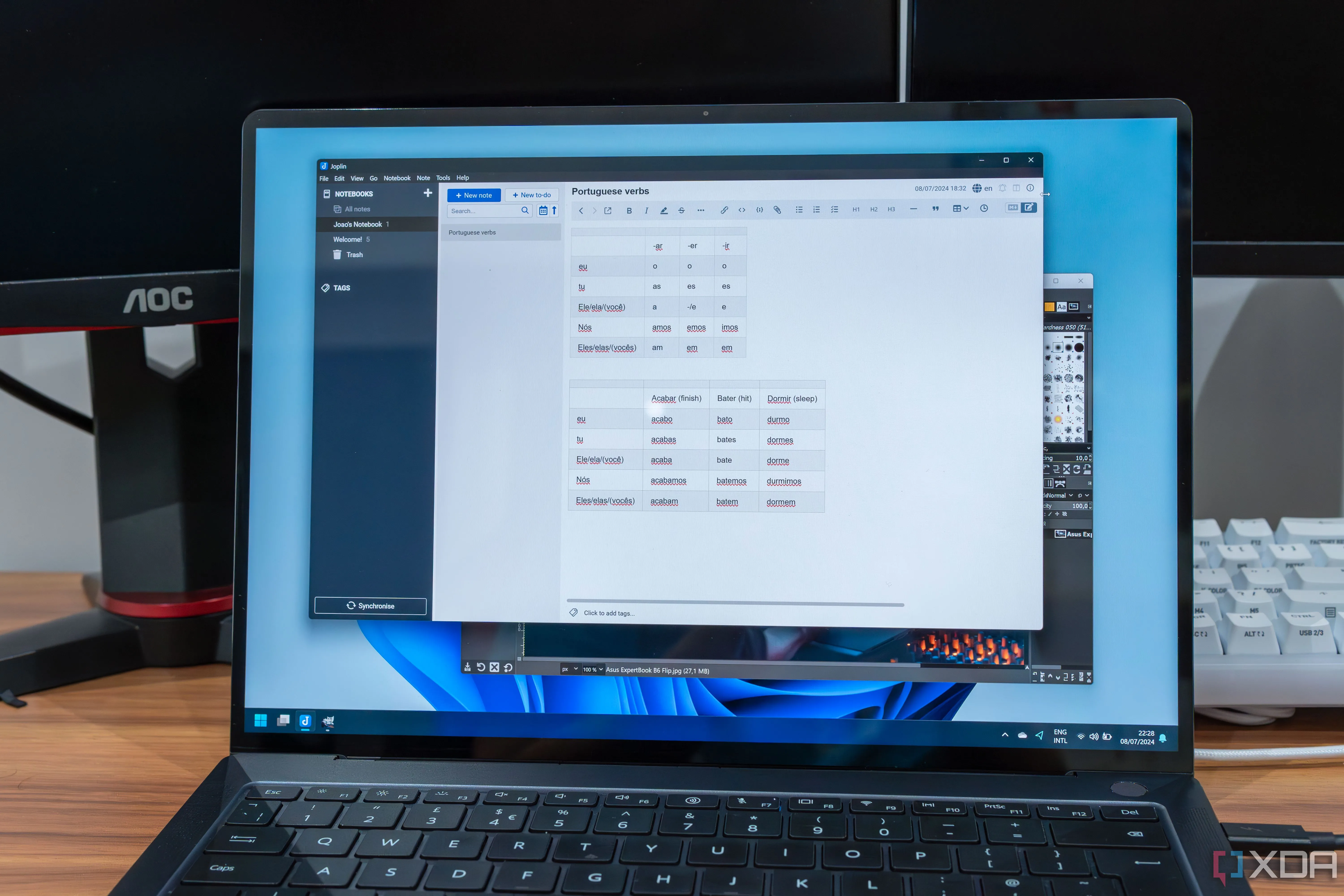 Một chiếc laptop hiển thị các phần mềm mã nguồn mở GIMP và Joplin, nhấn mạnh lợi ích của ứng dụng miễn phí và mã nguồn mở trên Windows