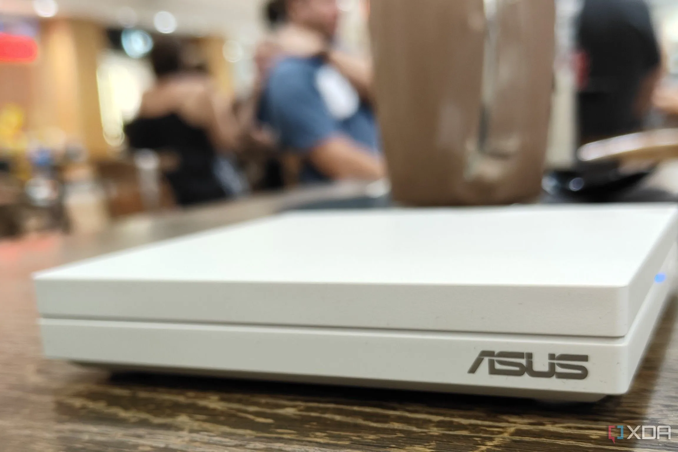 Một chiếc router du lịch nhỏ gọn đặt trên bàn tại sân bay, minh họa cho tầm quan trọng của việc tối ưu hóa thiết bị mạng cá nhân