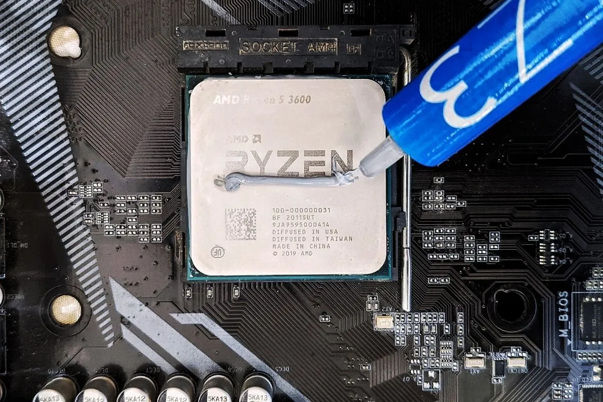 Một đường keo tản nhiệt được thoa đều lên bề mặt CPU, cho thấy quy trình lắp đặt để tối ưu truyền nhiệt.