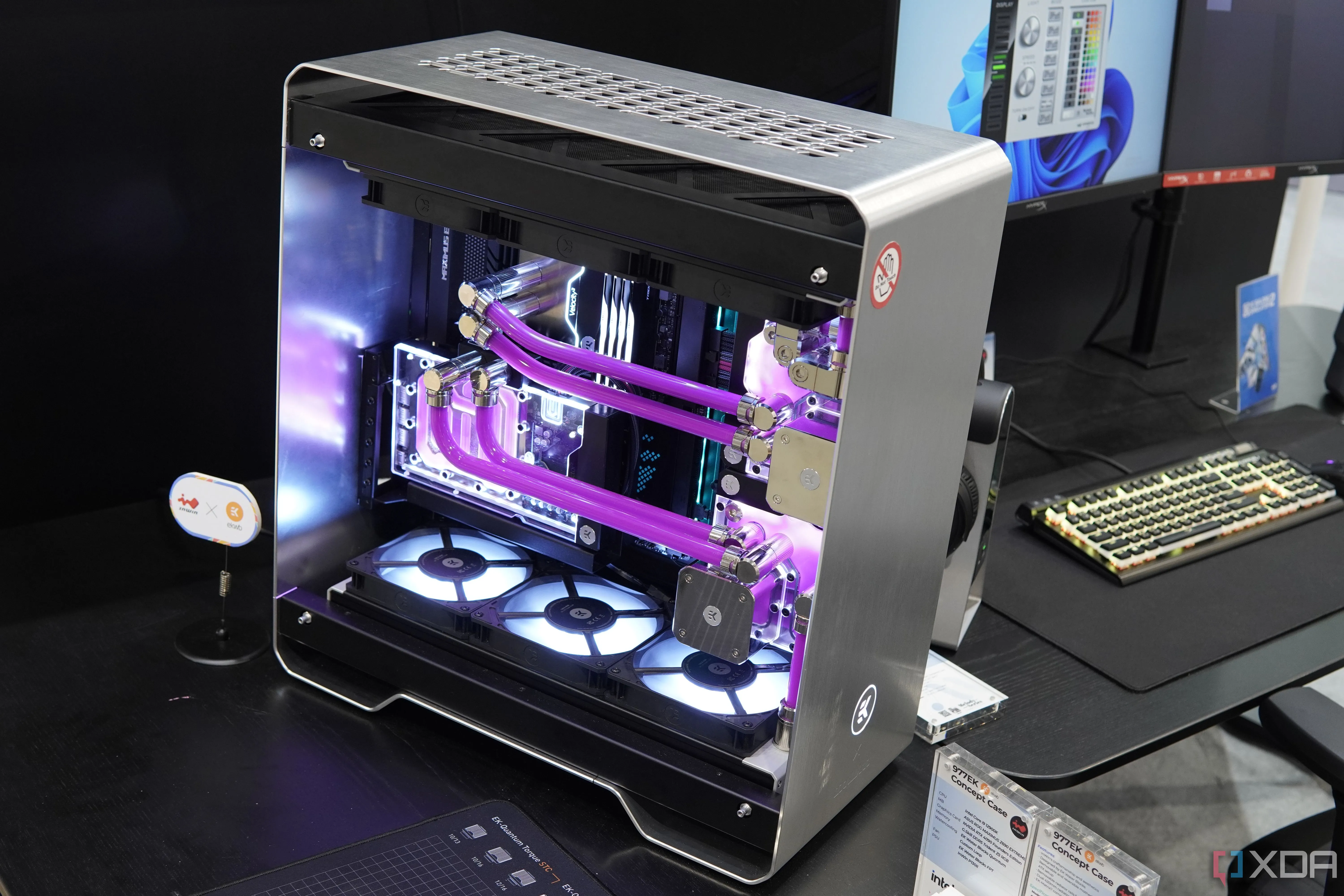 Một góc của bộ máy tính PC tùy chỉnh InWin 977EK với vỏ kim loại bạc và hai hệ thống tản nhiệt nước màu hồng