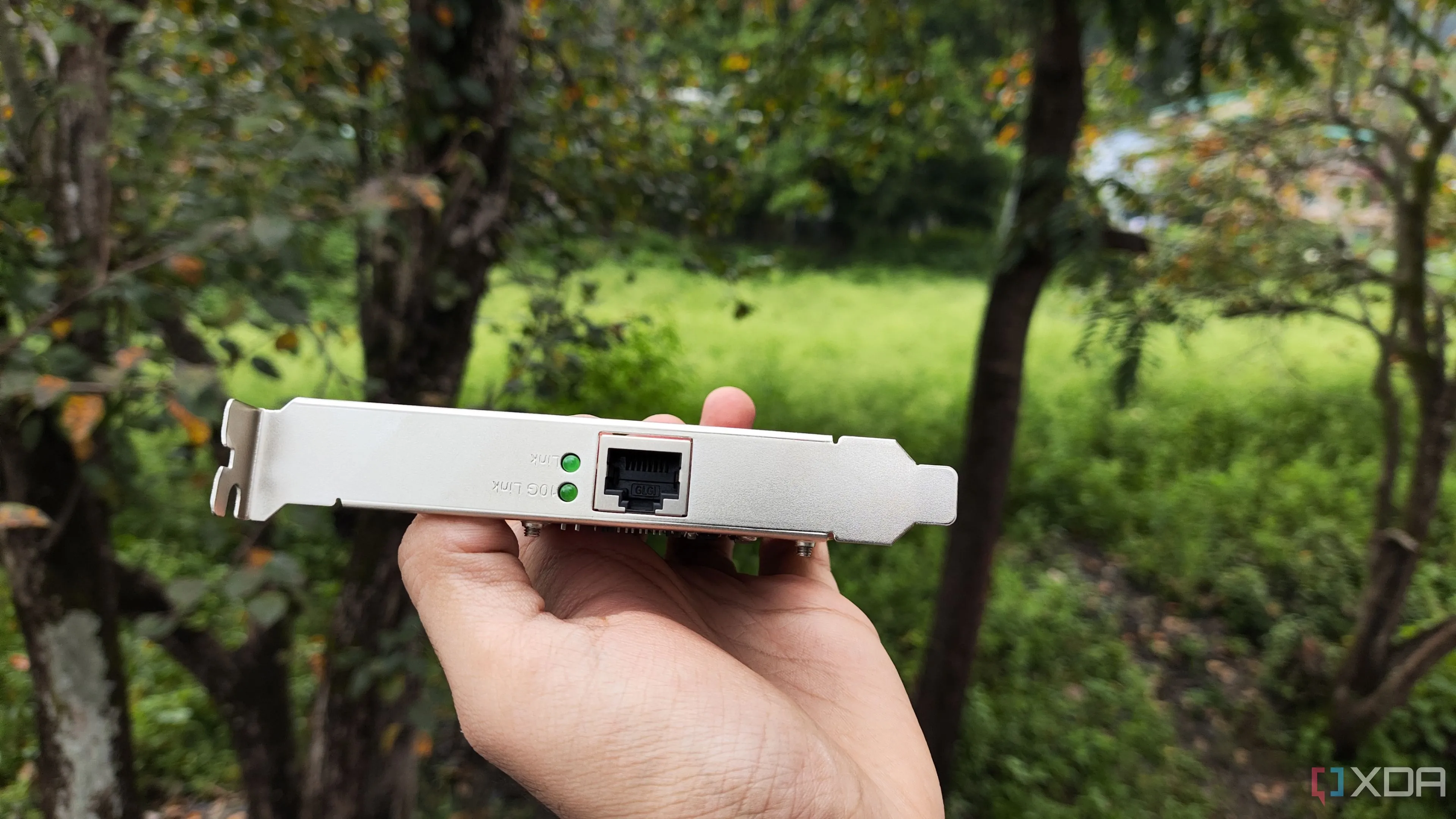 Một người đang cầm card mạng TP-Link 10 Gigabit Ethernet (10GbE) để nâng cấp hiệu suất mạng