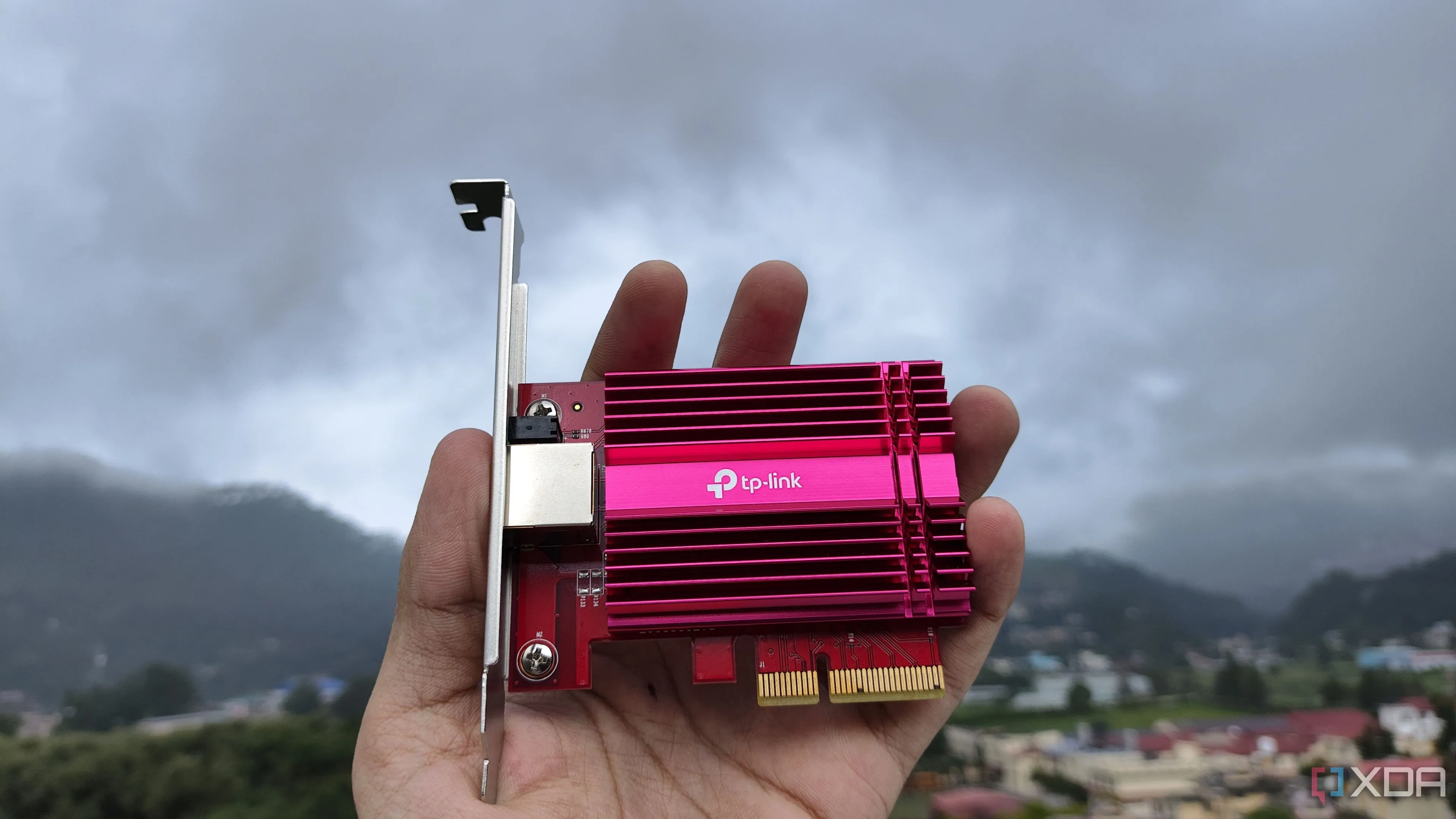 Một người đang cầm card mạng TP-Link 10G NIC, thành phần quan trọng của router tự dựng