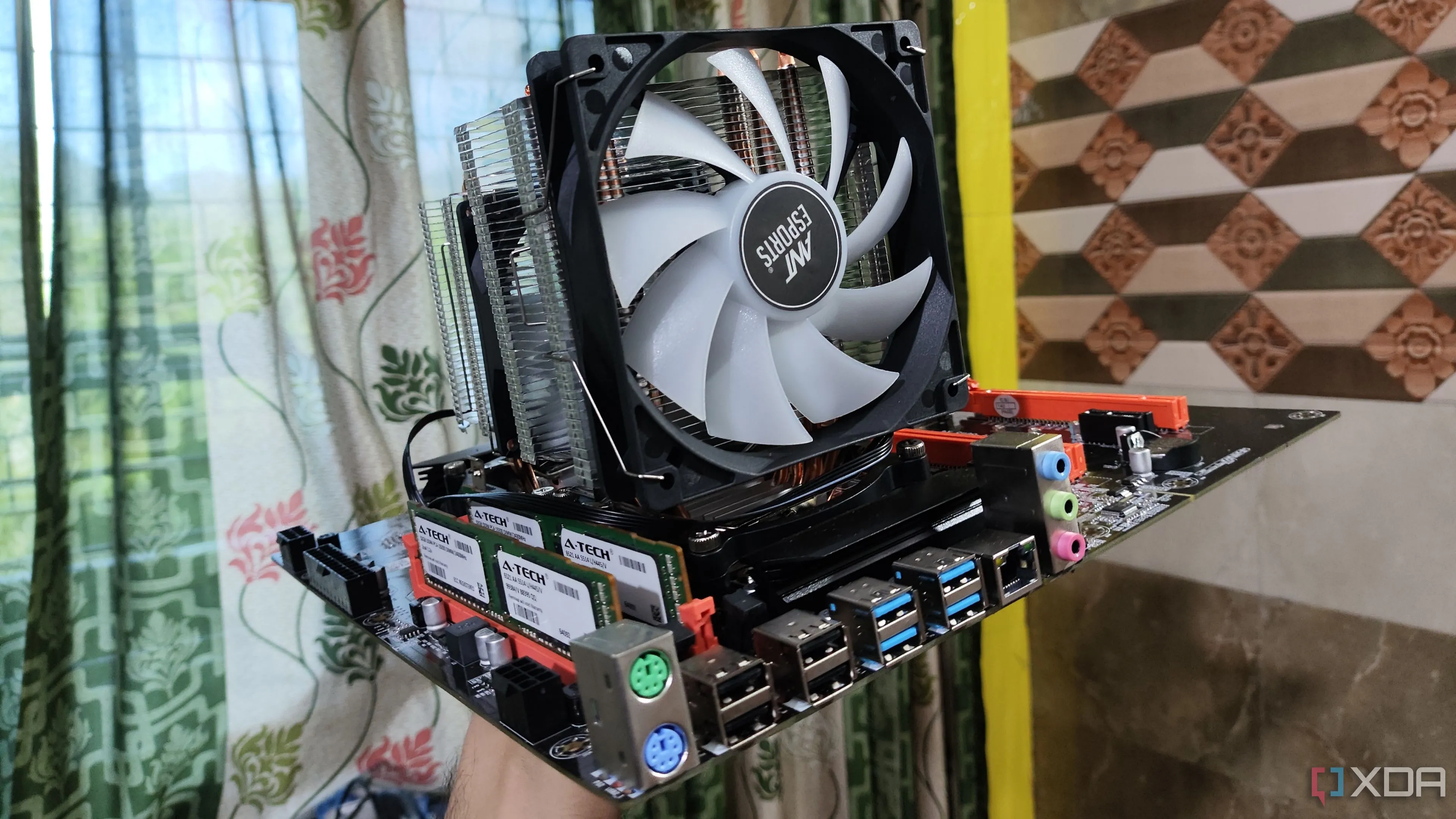 Một người đang cầm mainboard Dual Xeon X99, minh họa cho việc xây dựng PC không vỏ case với các linh kiện lộ thiên.