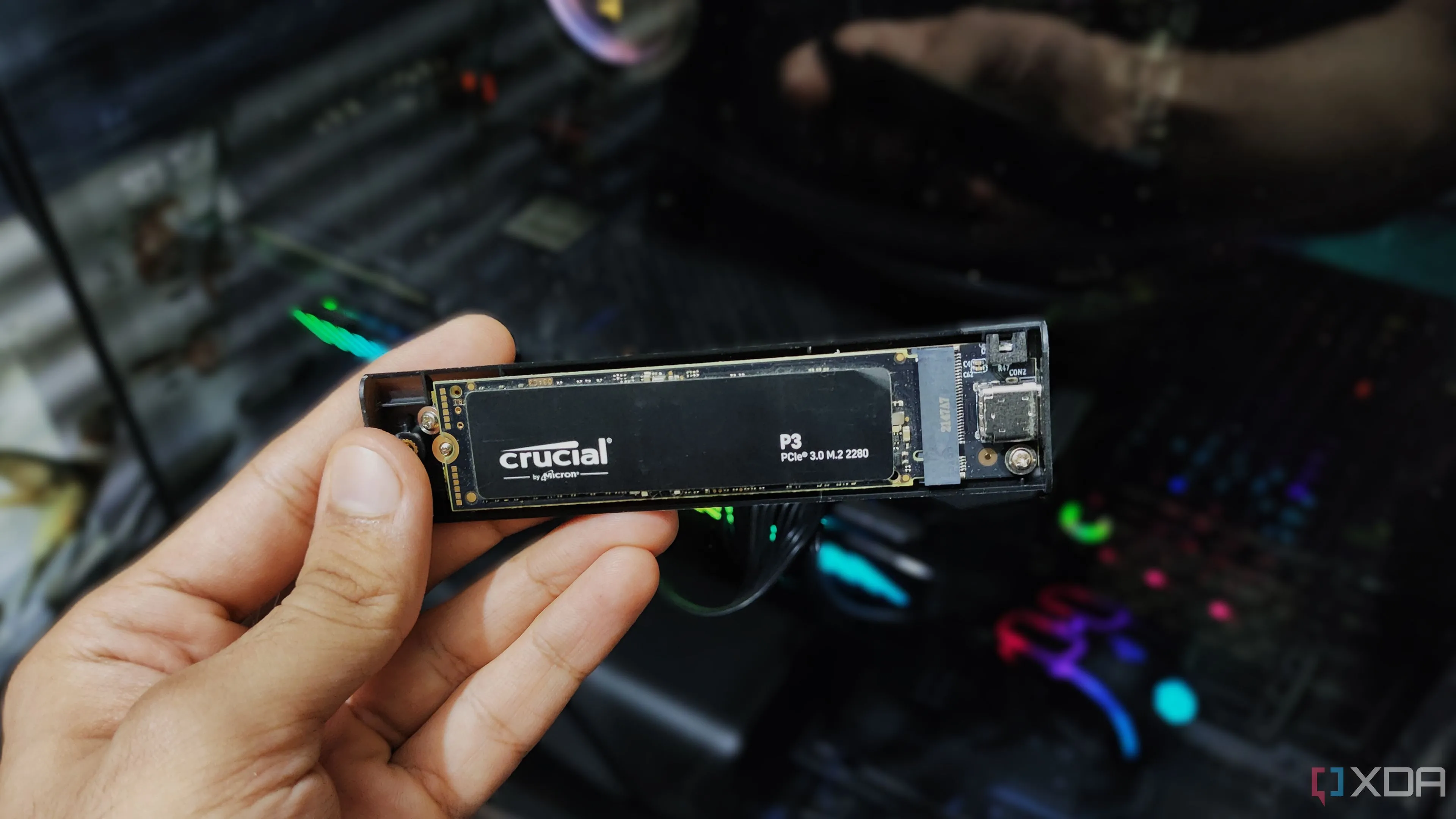 Một người đang cầm vỏ bọc cho ổ cứng SSD NVMe, nhấn mạnh tầm quan trọng của lưu trữ tốc độ cao