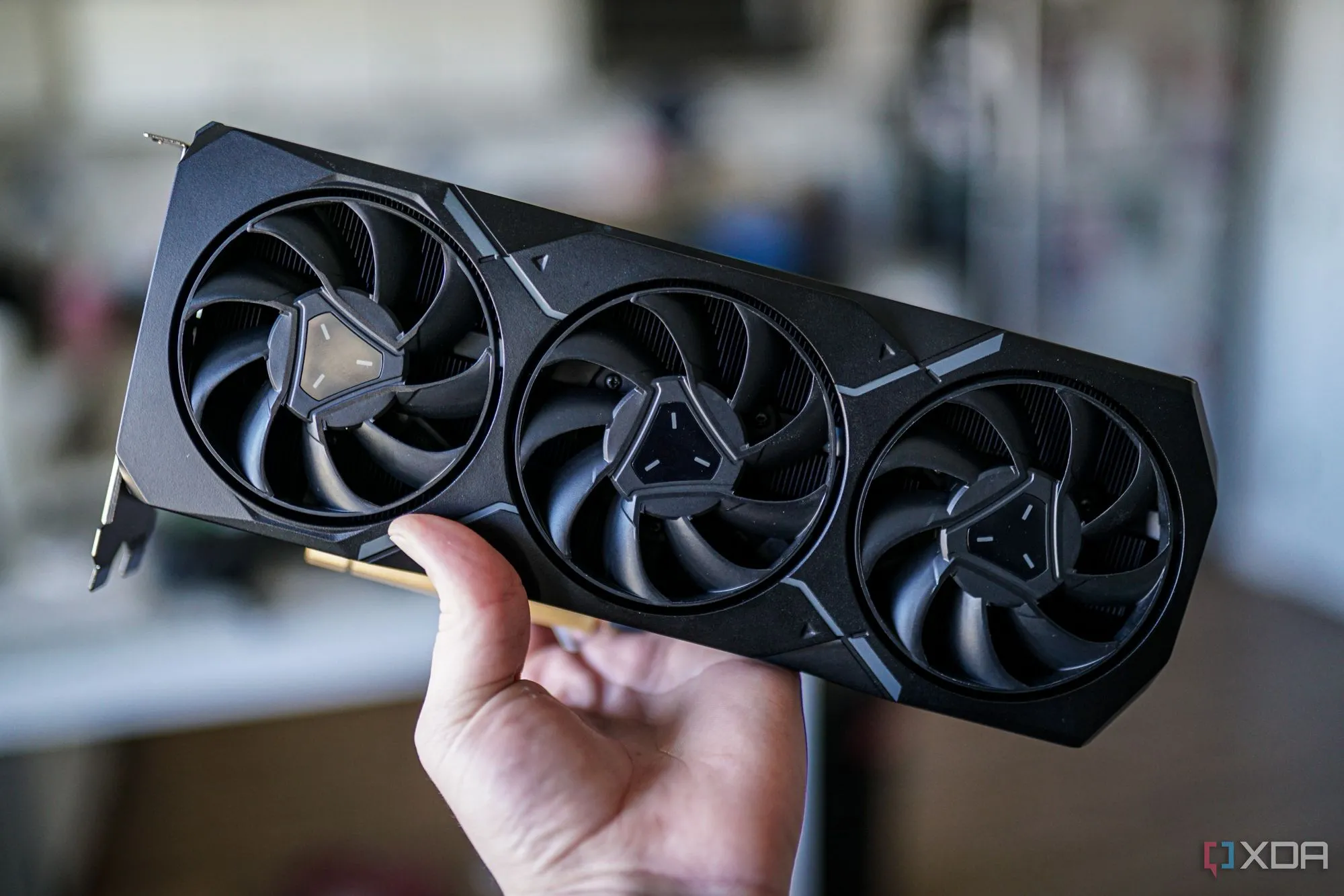 Một người dùng đang cầm card đồ họa AMD Radeon RX 7900 XT, biểu trưng cho sự cạnh tranh từ AMD trong thị trường GPU.