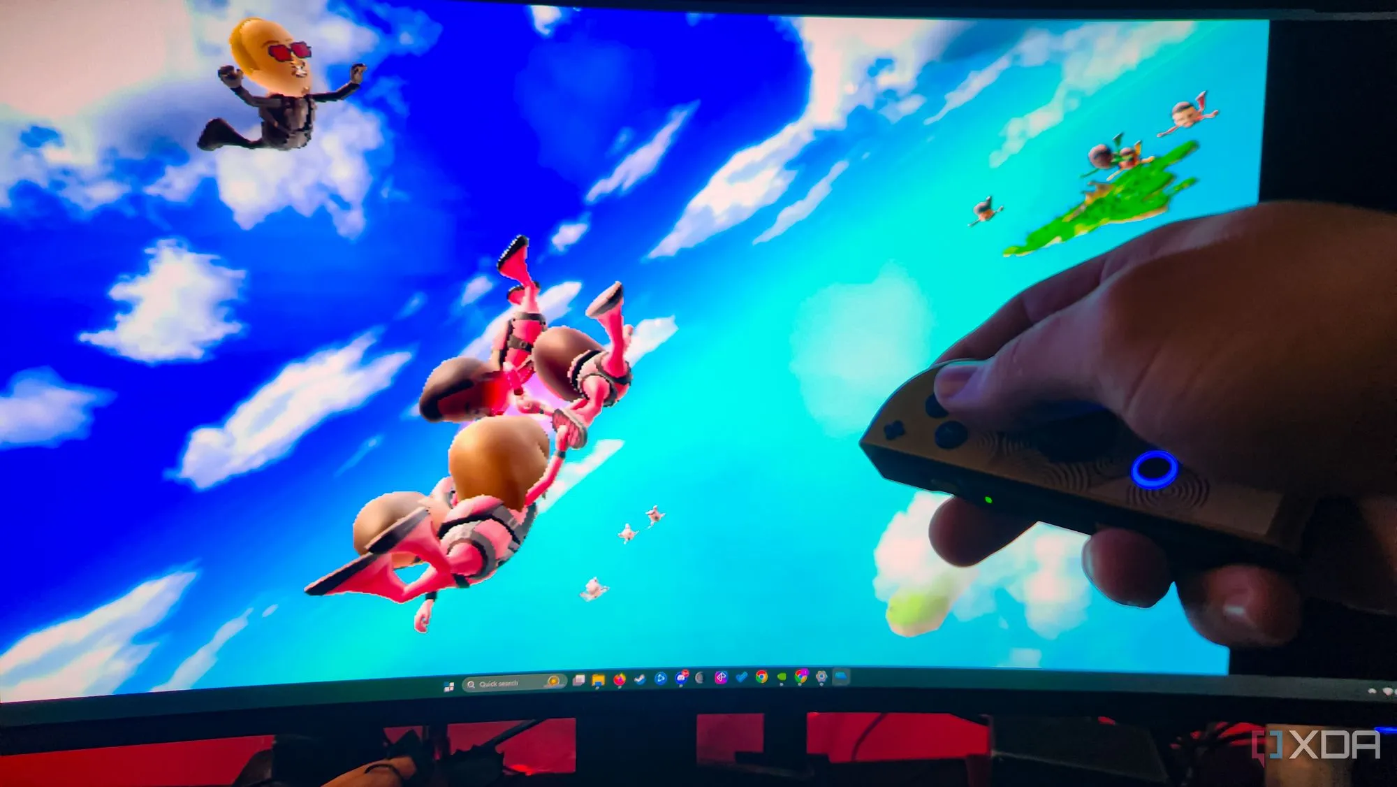 Người chơi đang nằm dài trên ghế sofa, tay cầm Joy-Con chơi game trên PC hiển thị trên màn hình lớn.