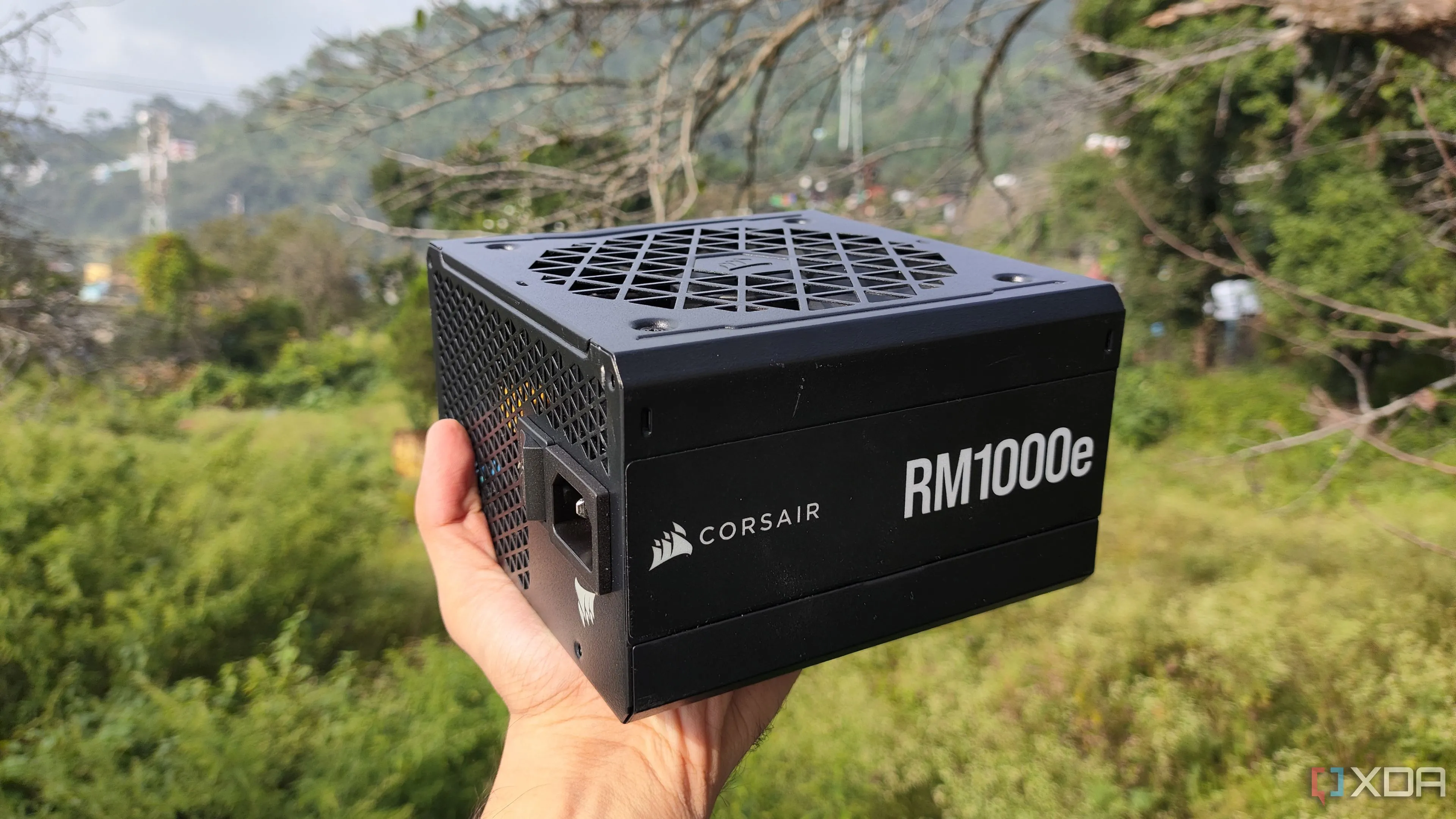 Người dùng cầm bộ nguồn Corsair RM1000e, minh họa PSU mạnh mẽ cần thiết cho RTX 5090