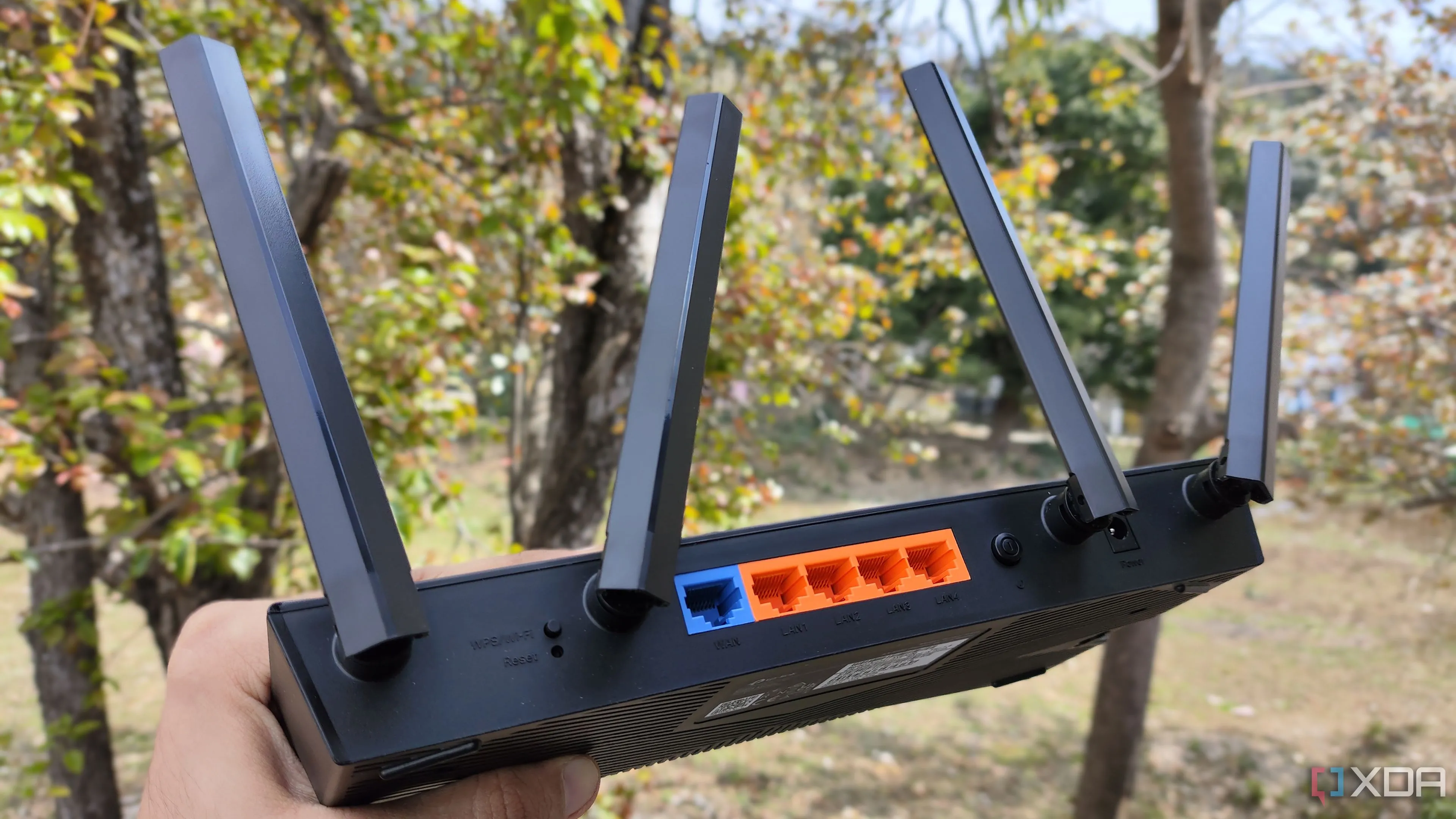 Người dùng đang cầm router TP-Link, tượng trưng cho việc kiểm soát và cấu hình bảo mật thiết bị mạng.