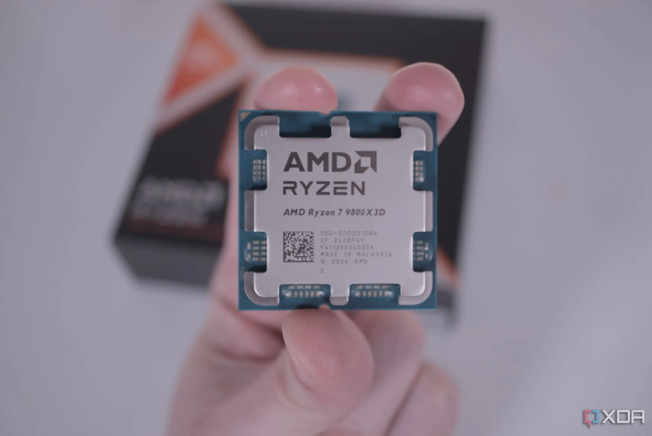 Người dùng đang cầm trên tay CPU AMD Ryzen 7 9800X3D, minh họa cho chip gaming đắt tiền
