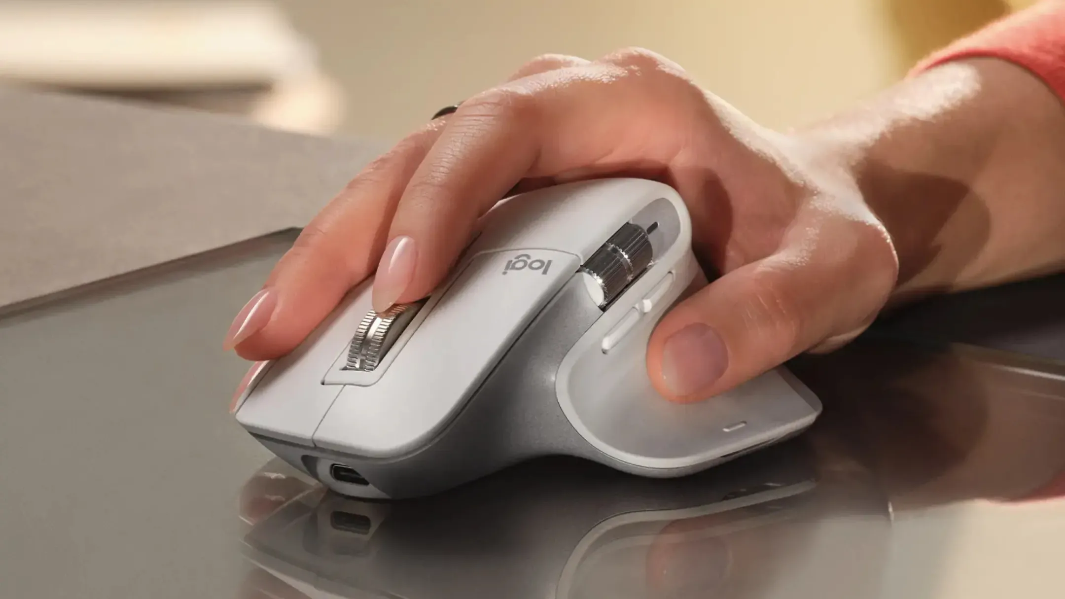 Người dùng đang sử dụng chuột Logitech MX Master 3S màu xám trên bàn làm việc