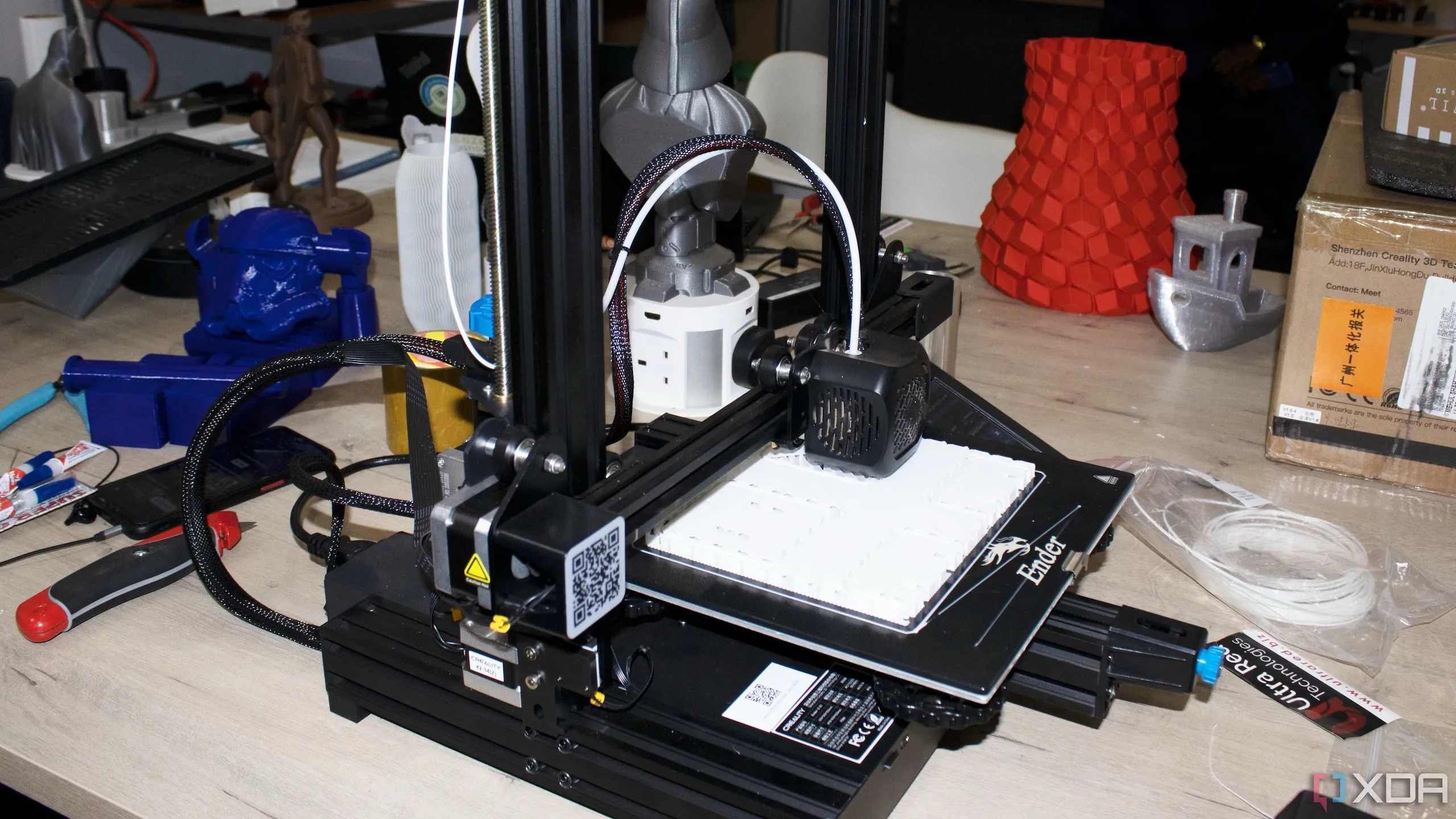 Nhiều vật phẩm in 3D được sắp xếp trên một chiếc kệ gỗ