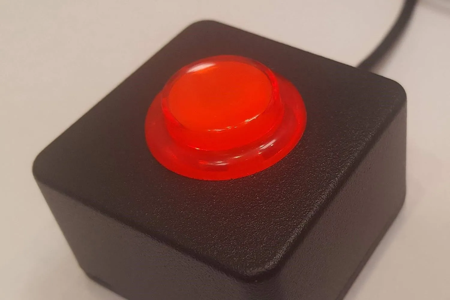 Nút bấm arcade lớn màu đỏ trên hộp đen, kết nối qua USB, có thể lập trình để thực hiện các chức năng tùy chỉnh trên máy tính như tắt máy hoặc khóa màn hình.