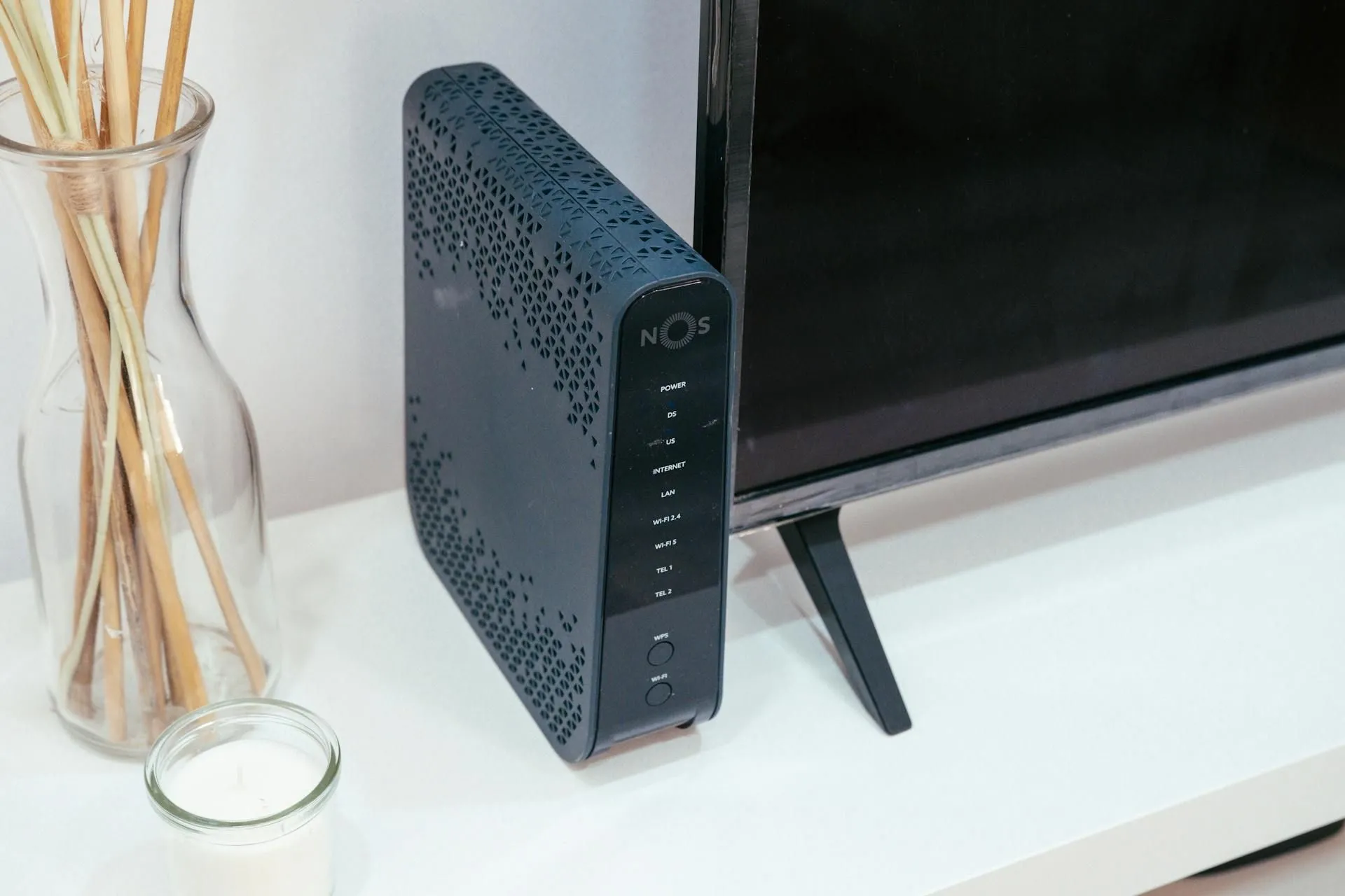 Router đặt cạnh TV và nến thơm