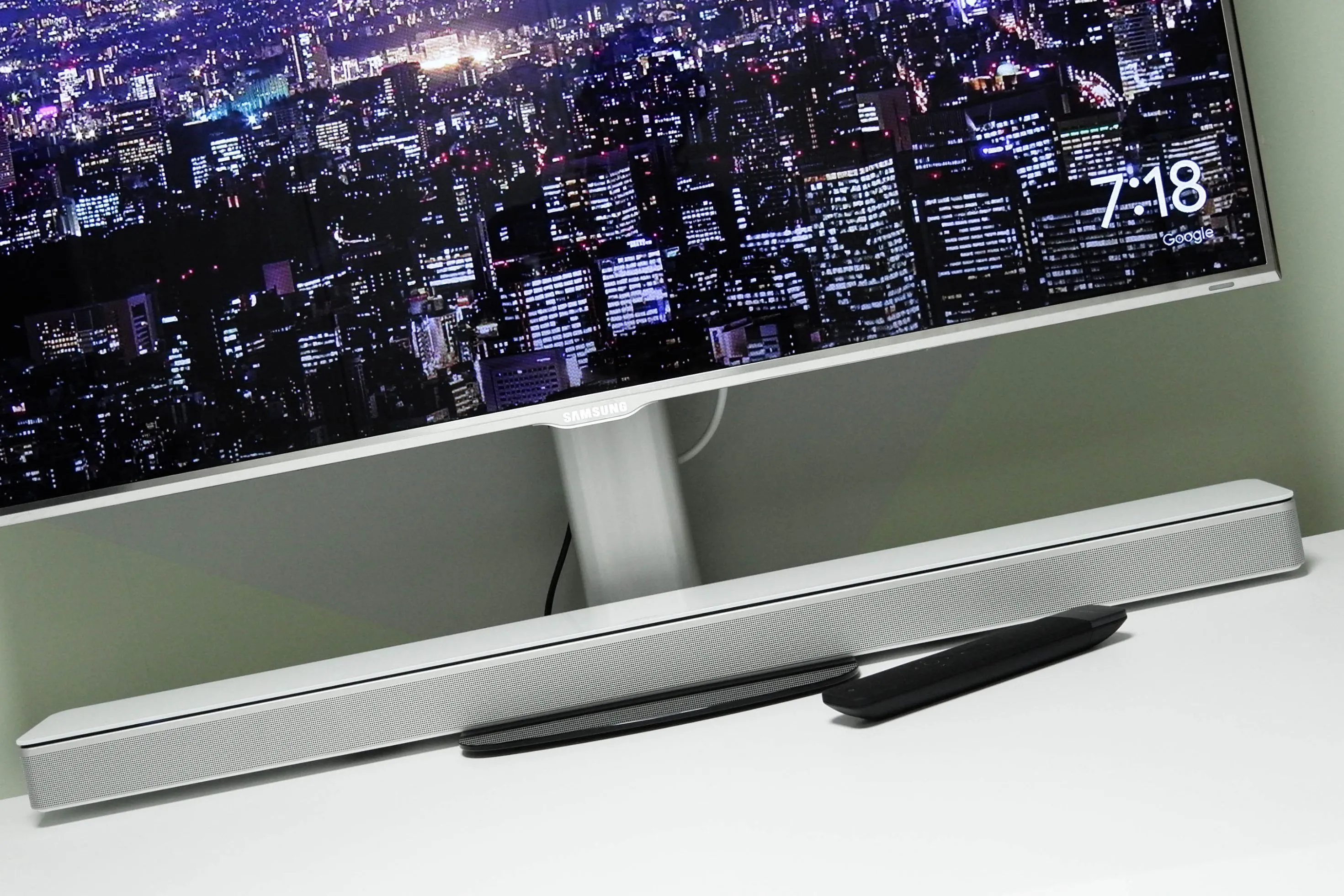 Soundbar đặt gọn gàng dưới màn hình máy tính trên bàn làm việc