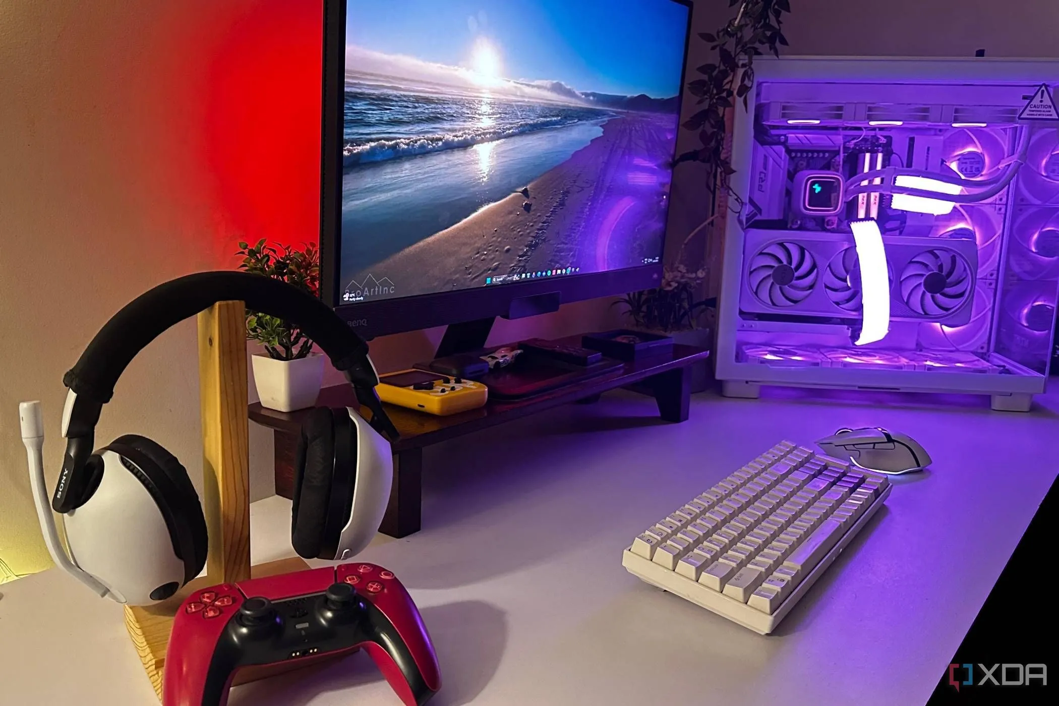 Tai nghe Sony Inzone và tay cầm DualSense màu đỏ trên bàn làm việc cùng PC gaming, tượng trưng cho trải nghiệm chơi game tổng thể và các phụ kiện quan trọng.